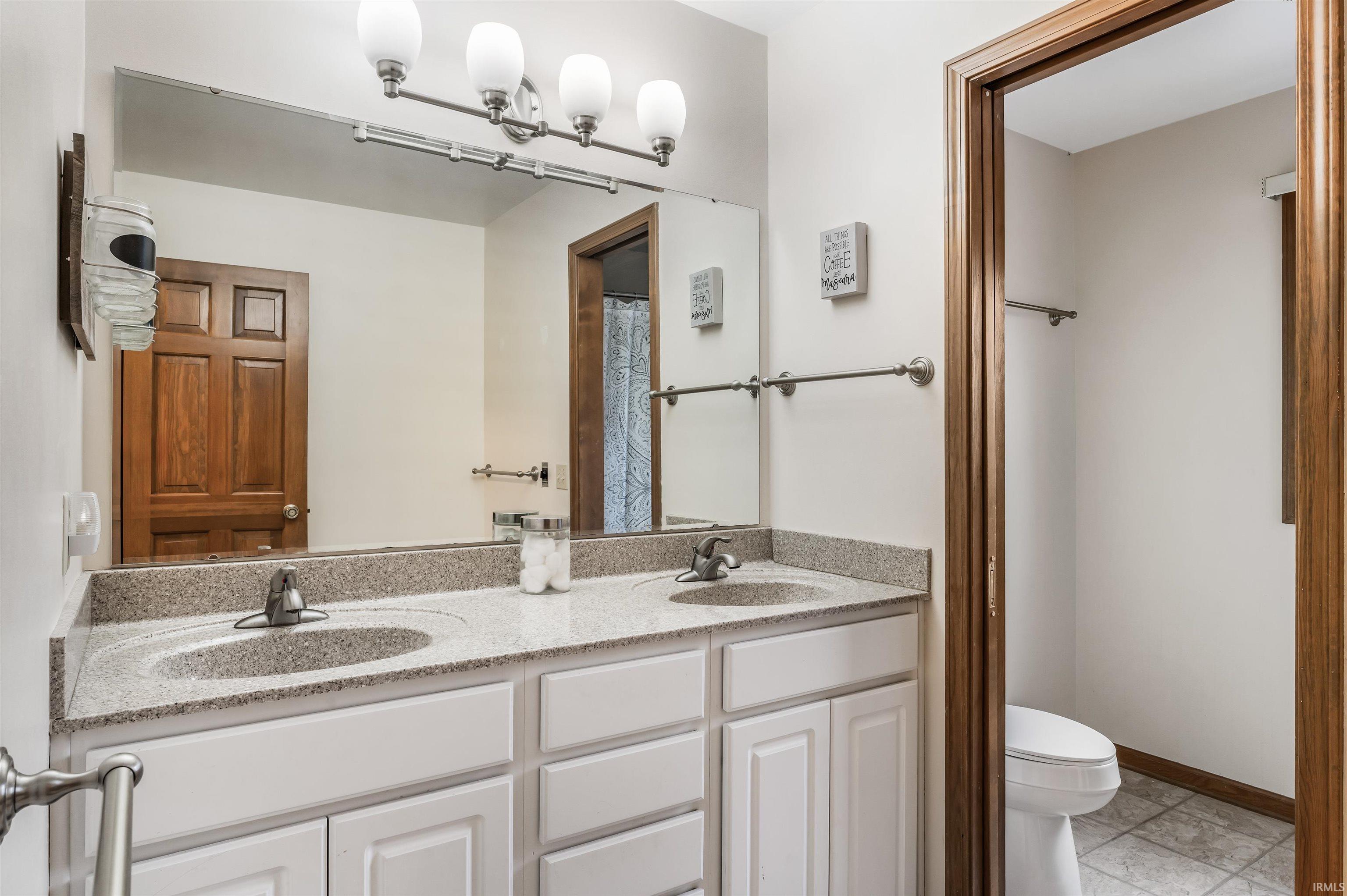 Full bath featuring double vanity and curtained shower