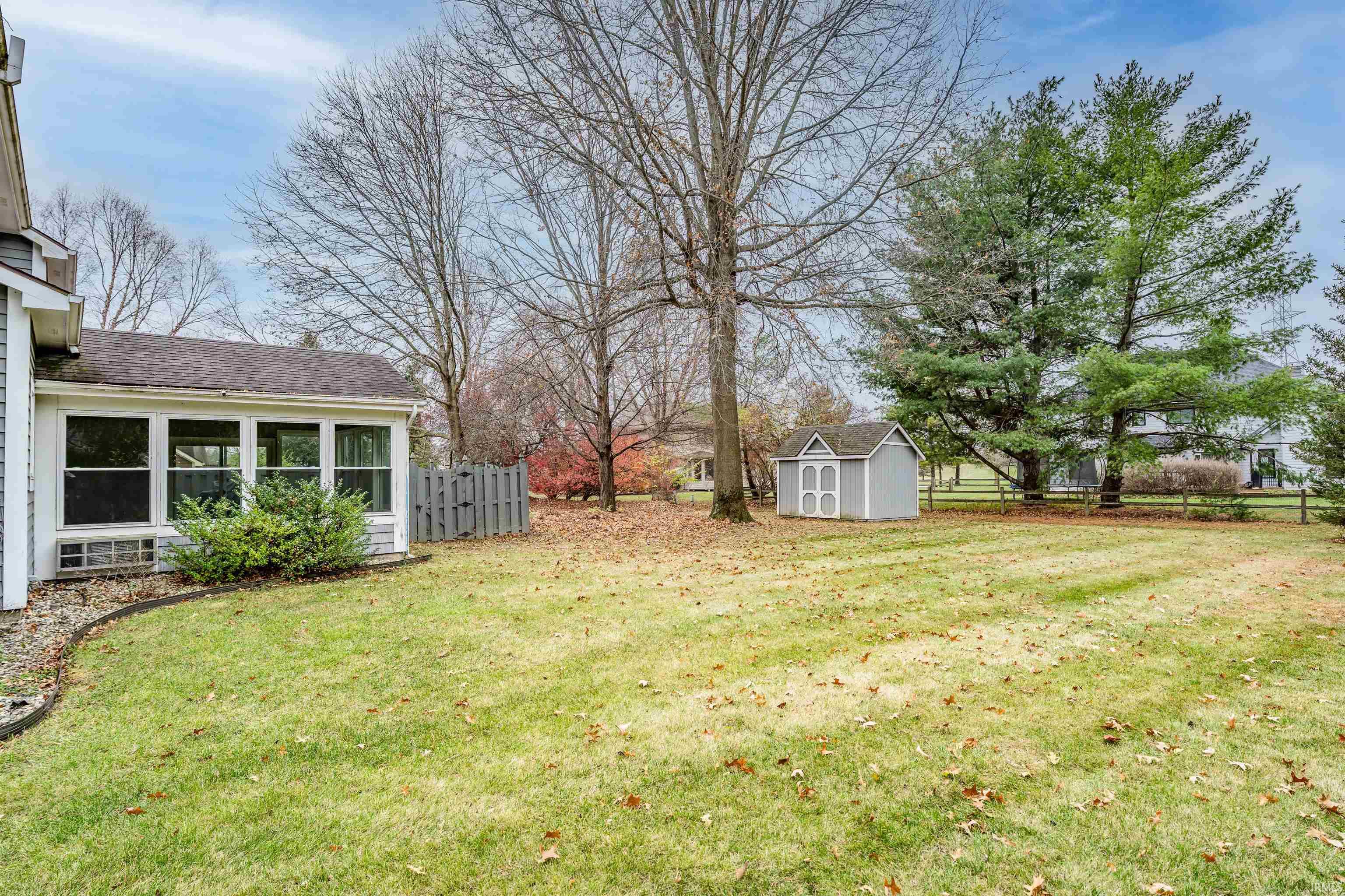 View of yard with a sunroom and a storage unit
