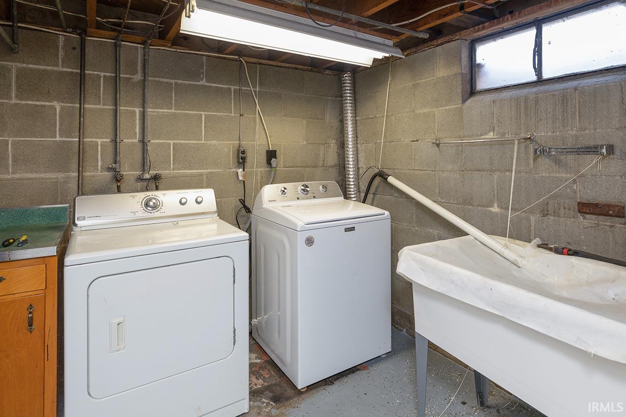 Laundry area featuring washing machine and clothes dryer and a sink