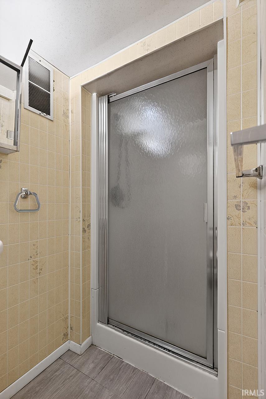 Full bath featuring a shower stall