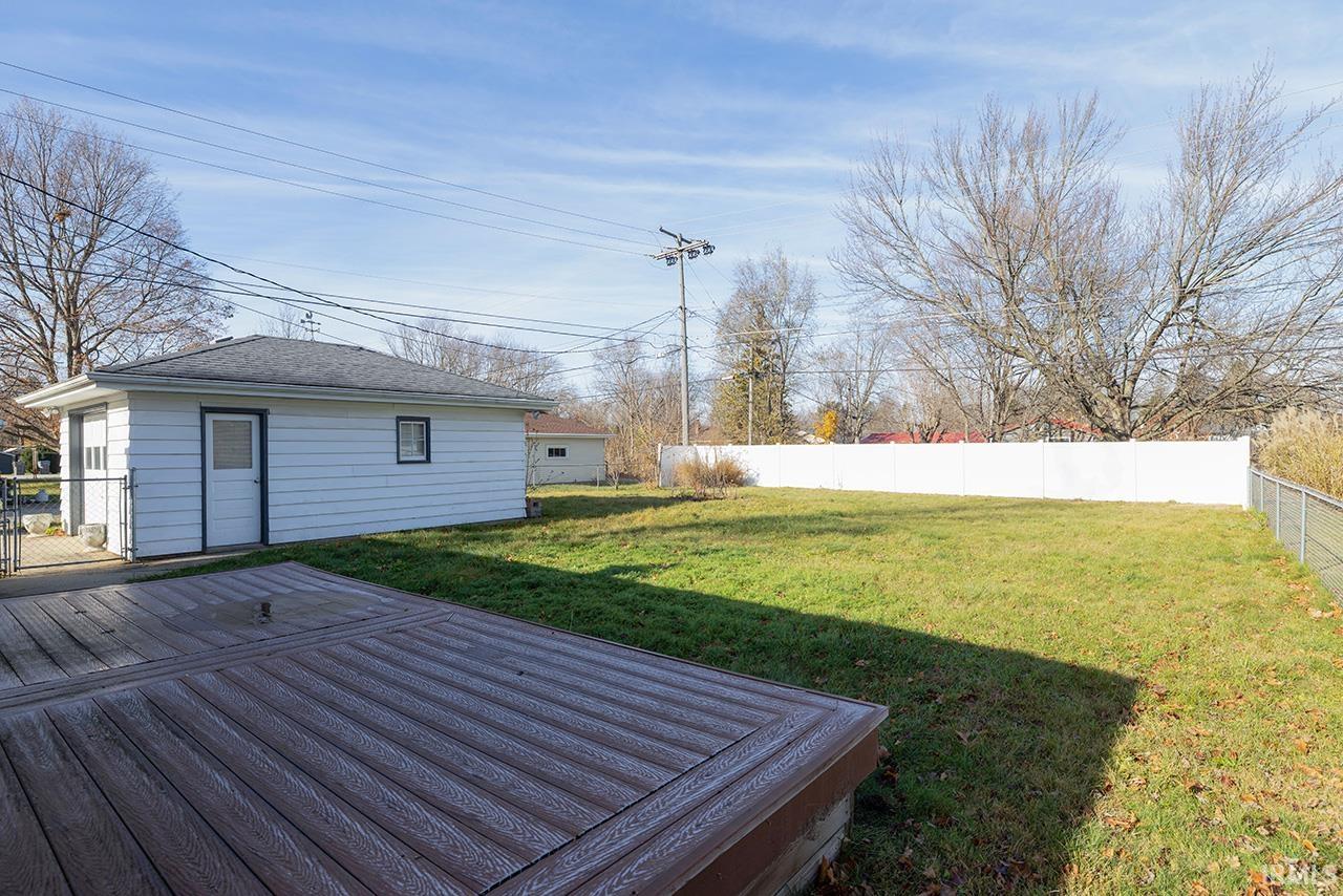 Fenced backyard featuring a deck and a gate