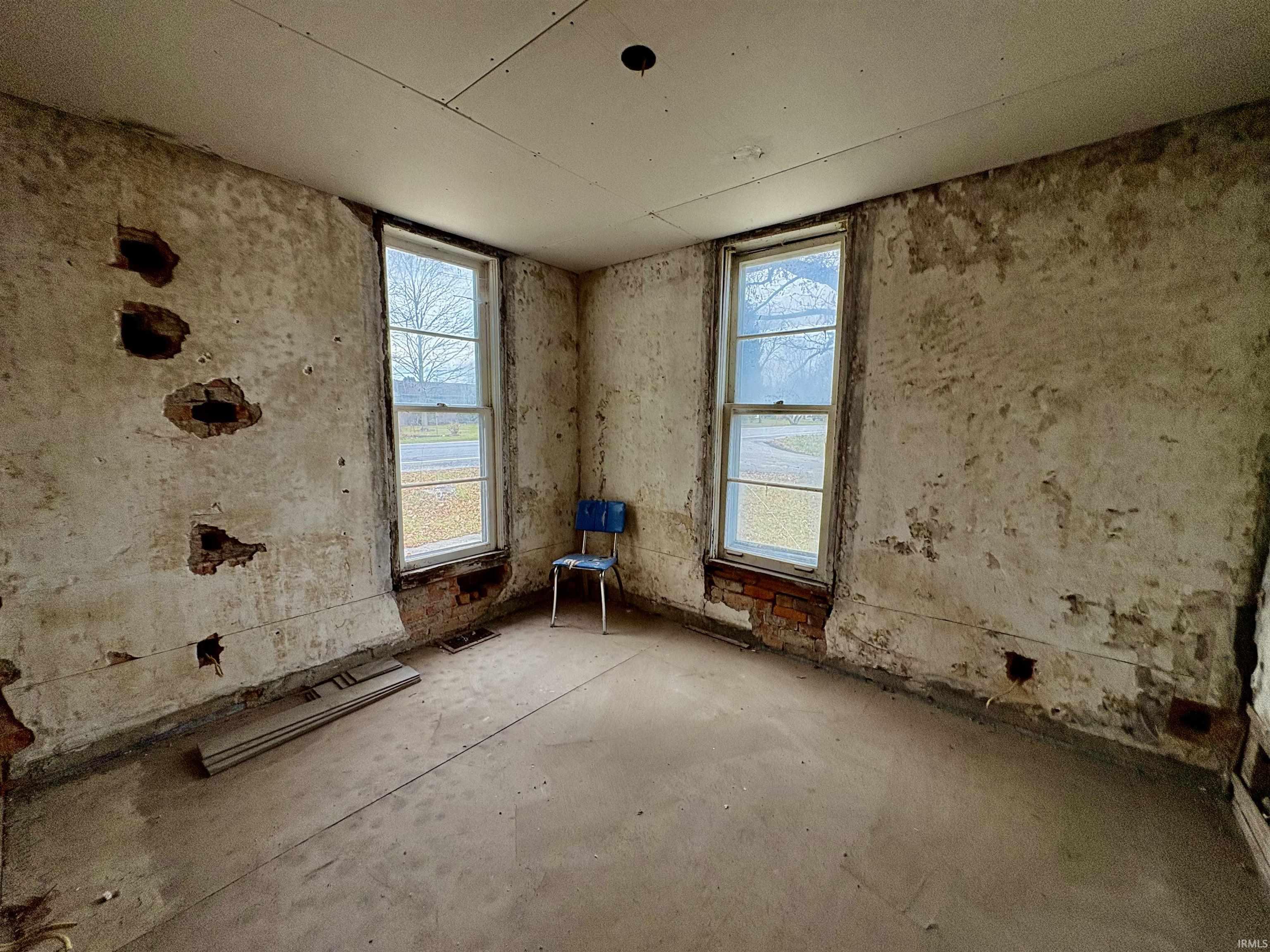 Unfurnished room featuring healthy amount of natural light and concrete flooring