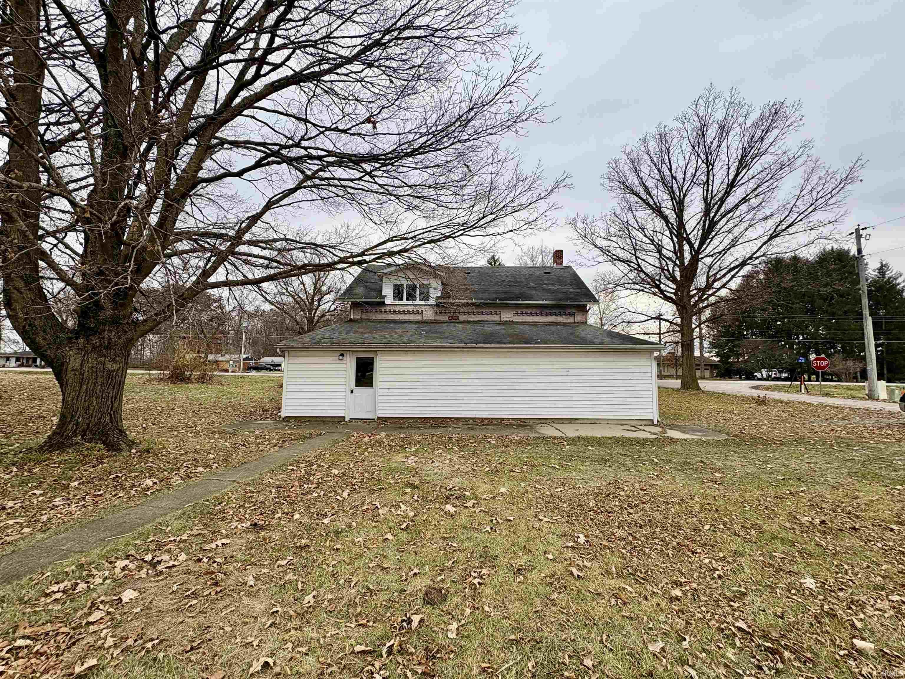 View of property exterior featuring a chimney and a yard