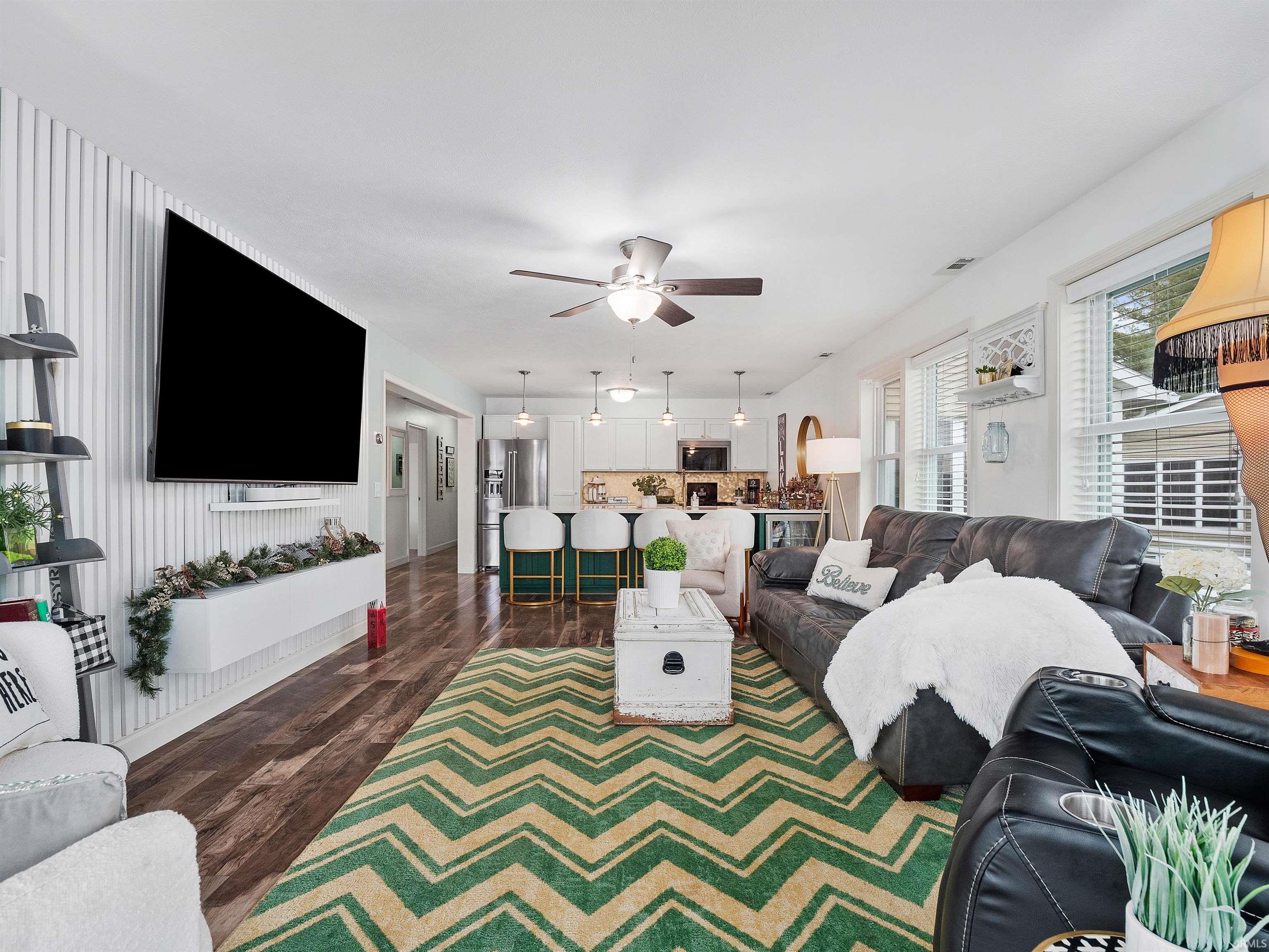 Living area featuring ceiling fan and dark wood finished floors