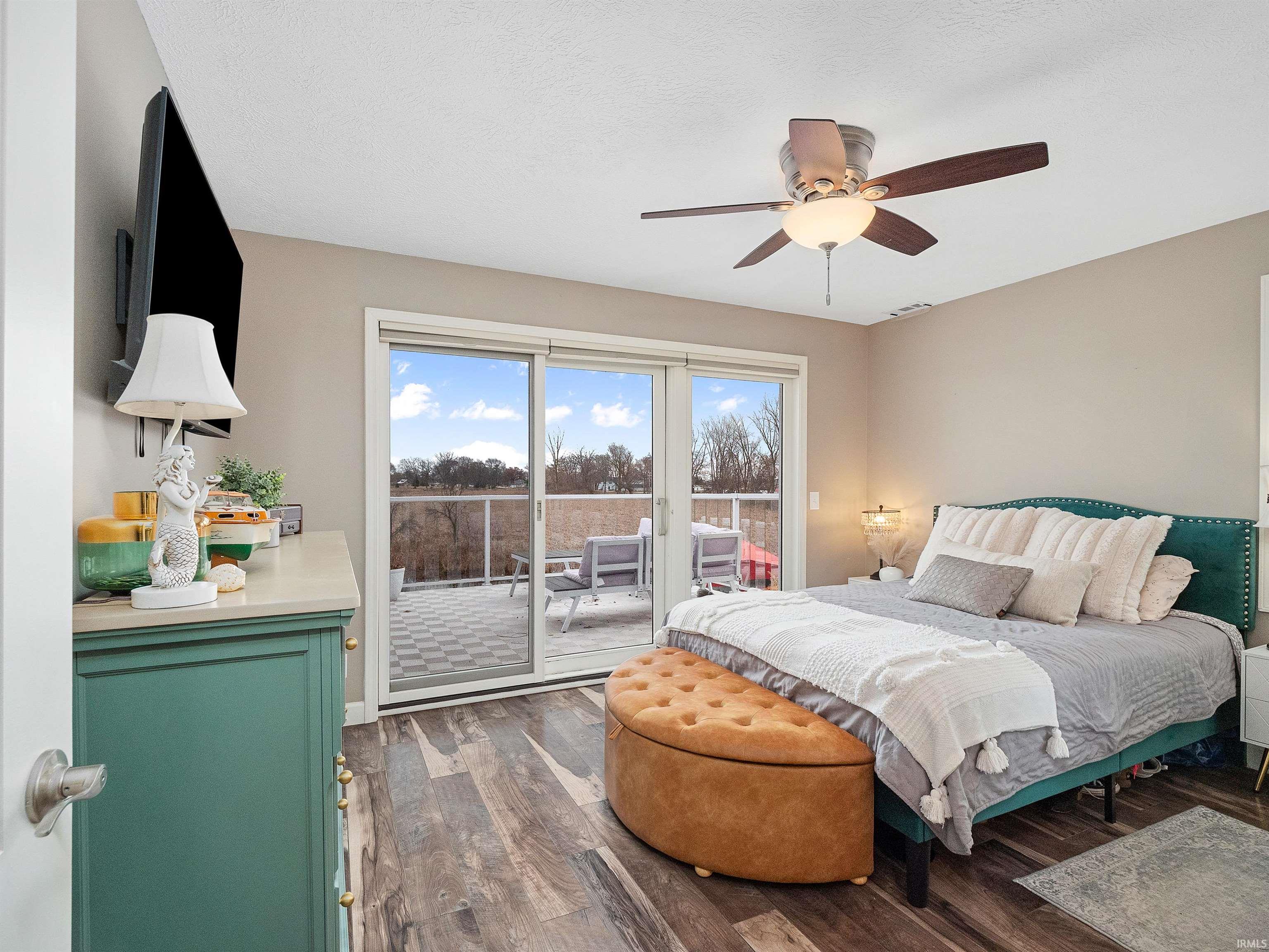 Bedroom with access to outside, dark wood-style floors, and ceiling fan