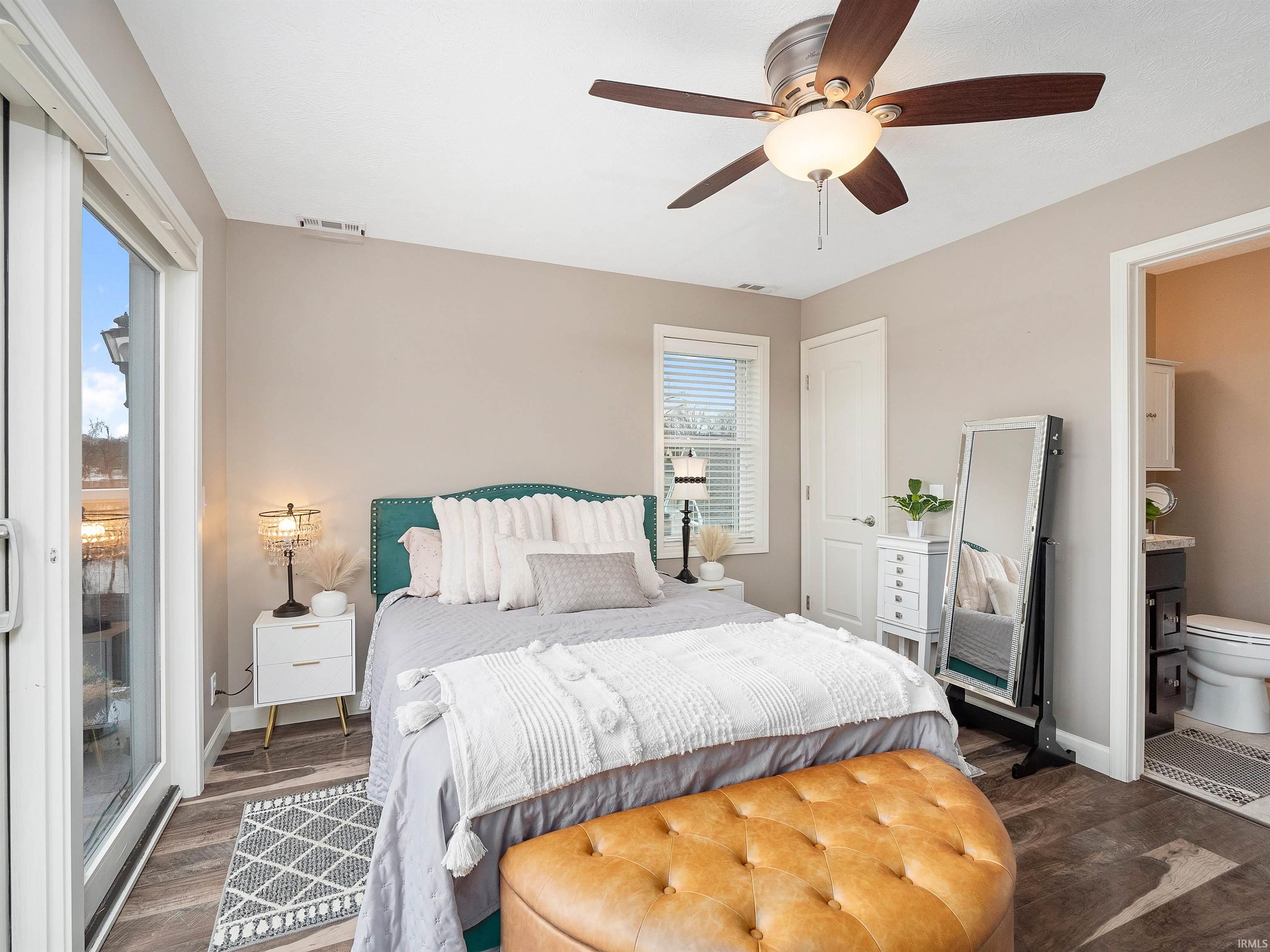 Bedroom with ceiling fan, dark wood finished floors, and ensuite bathroom