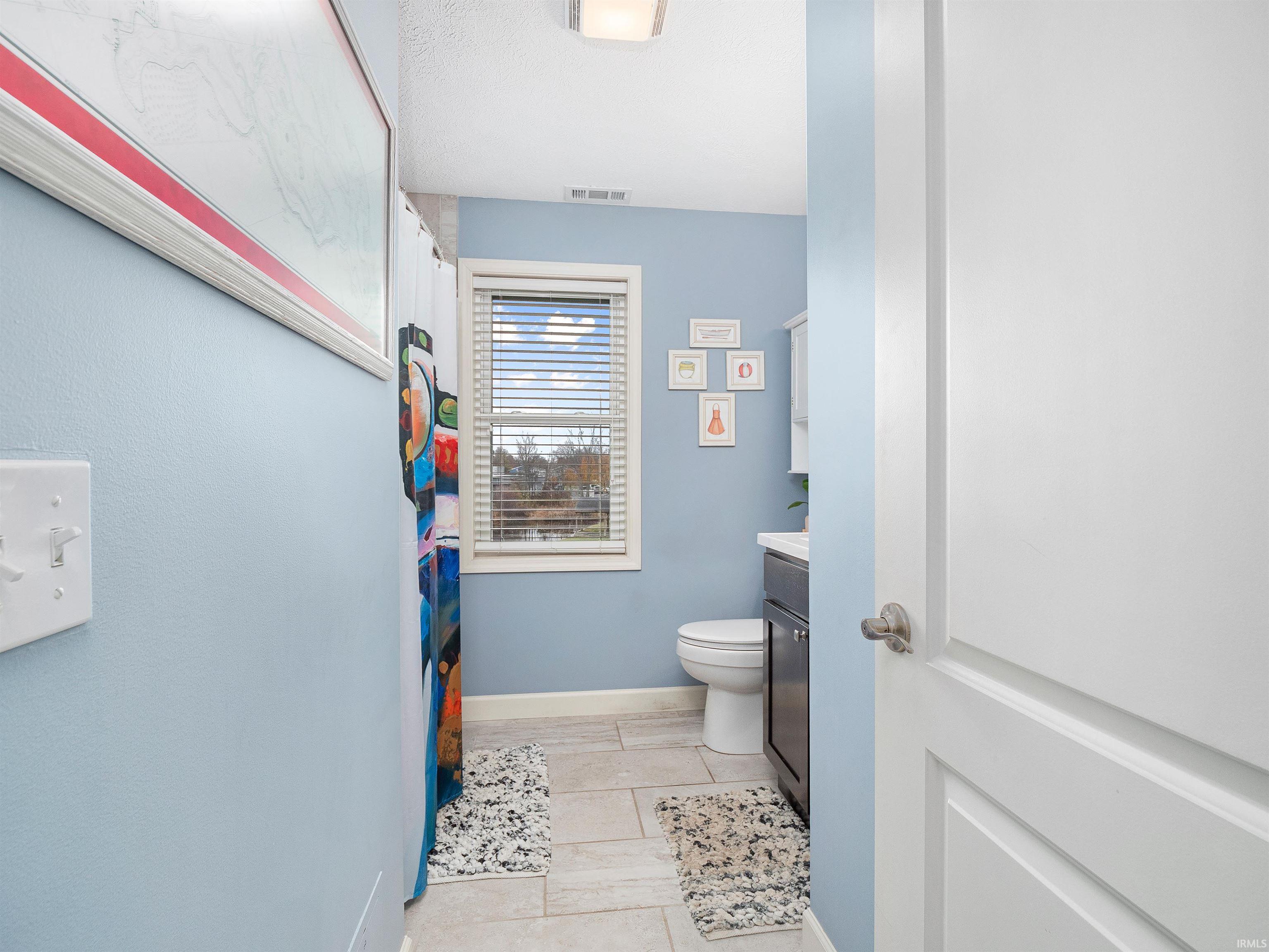 Bathroom with vanity, a shower with curtain, and light tile patterned floors