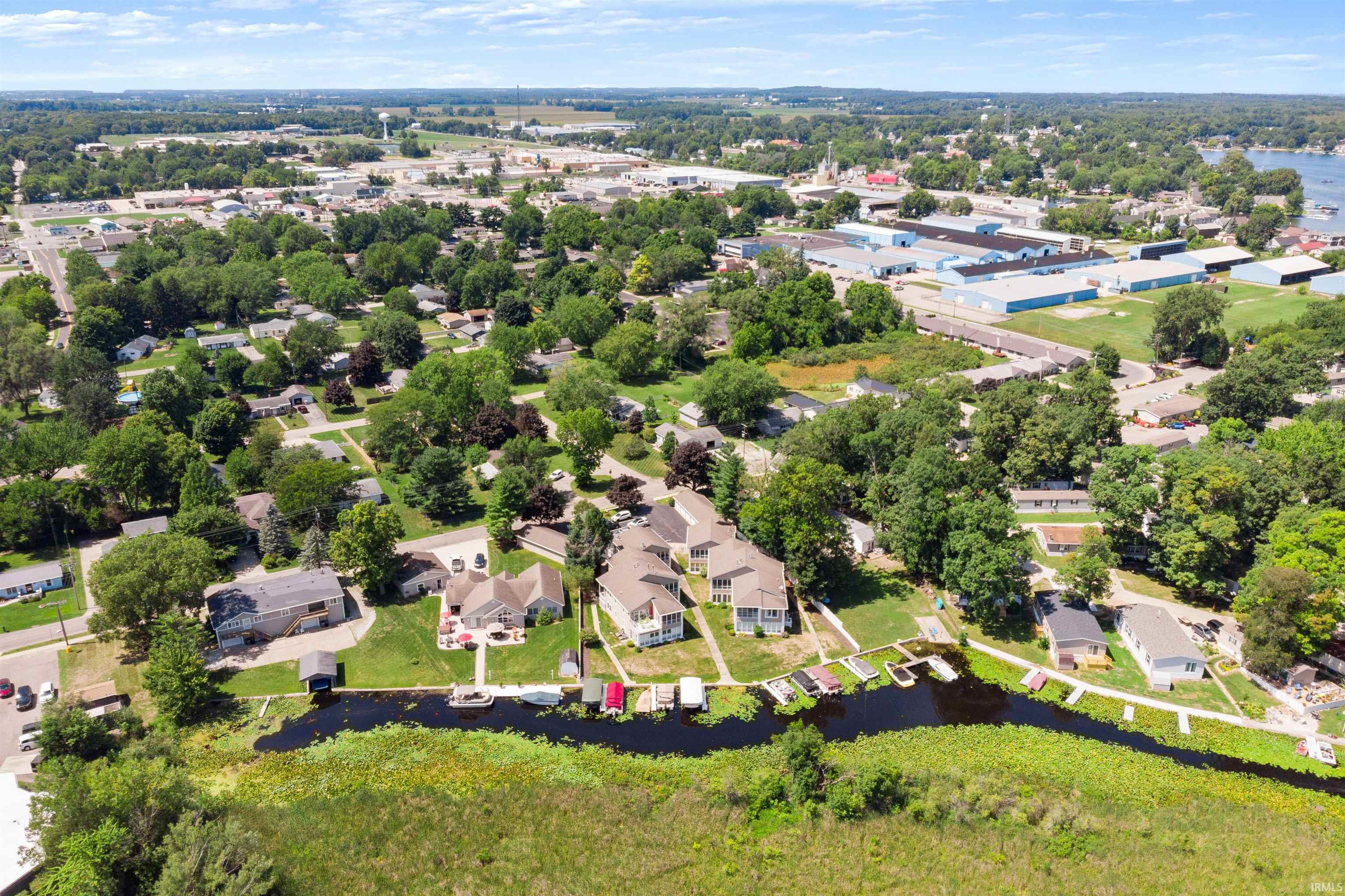 Aerial perspective of suburban area with a tree filled landscape and a large body of water