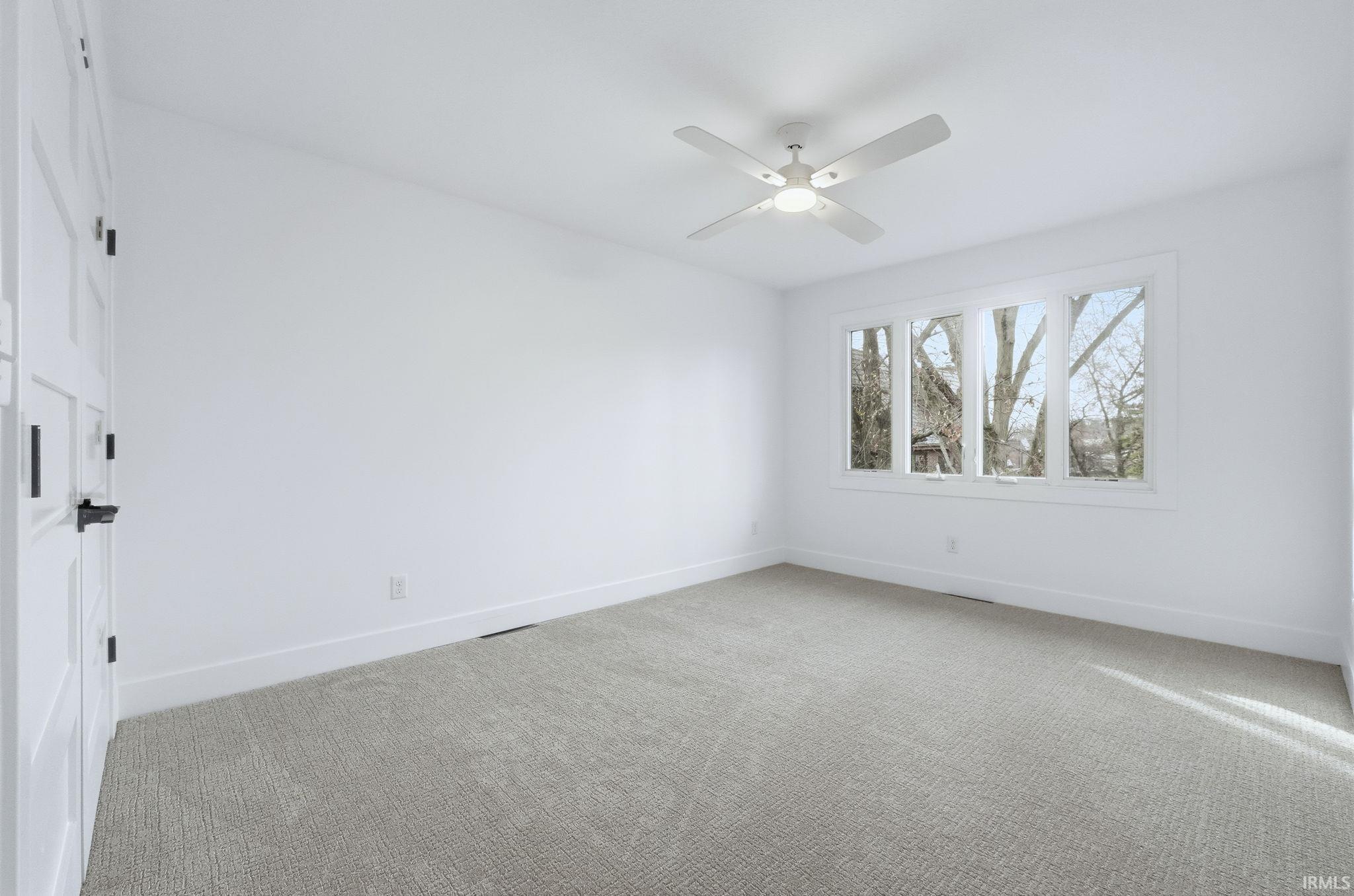 Spare room with light carpet and ceiling fan
