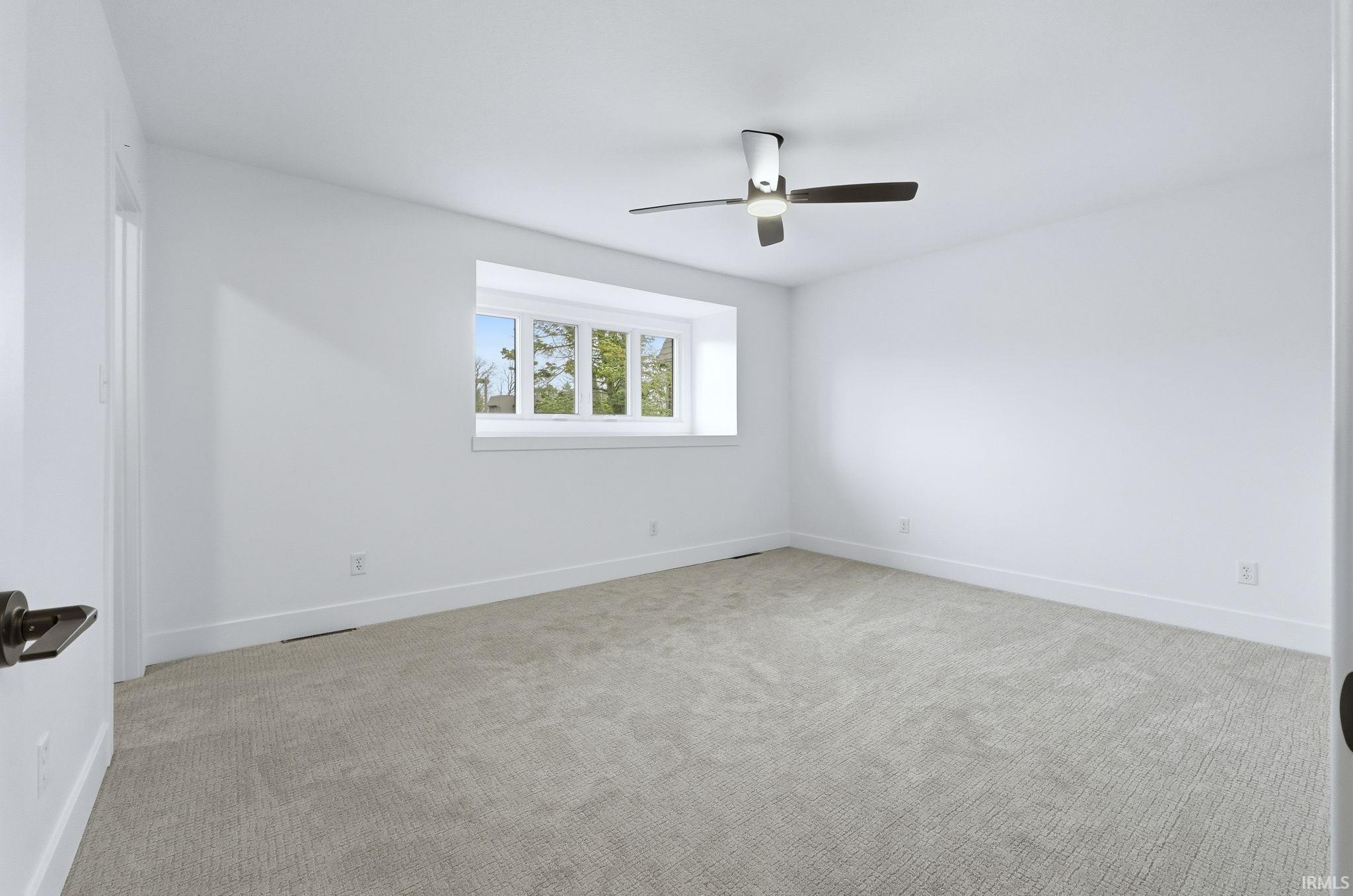 Spare room featuring light colored carpet and ceiling fan