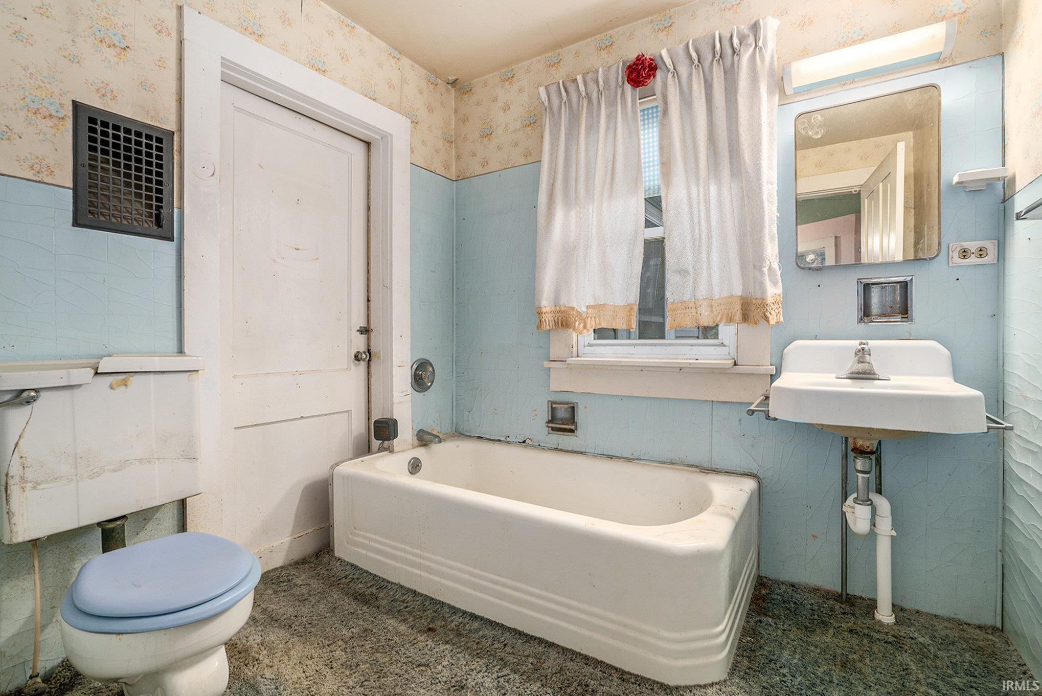 Bathroom with a garden tub and wallpapered walls