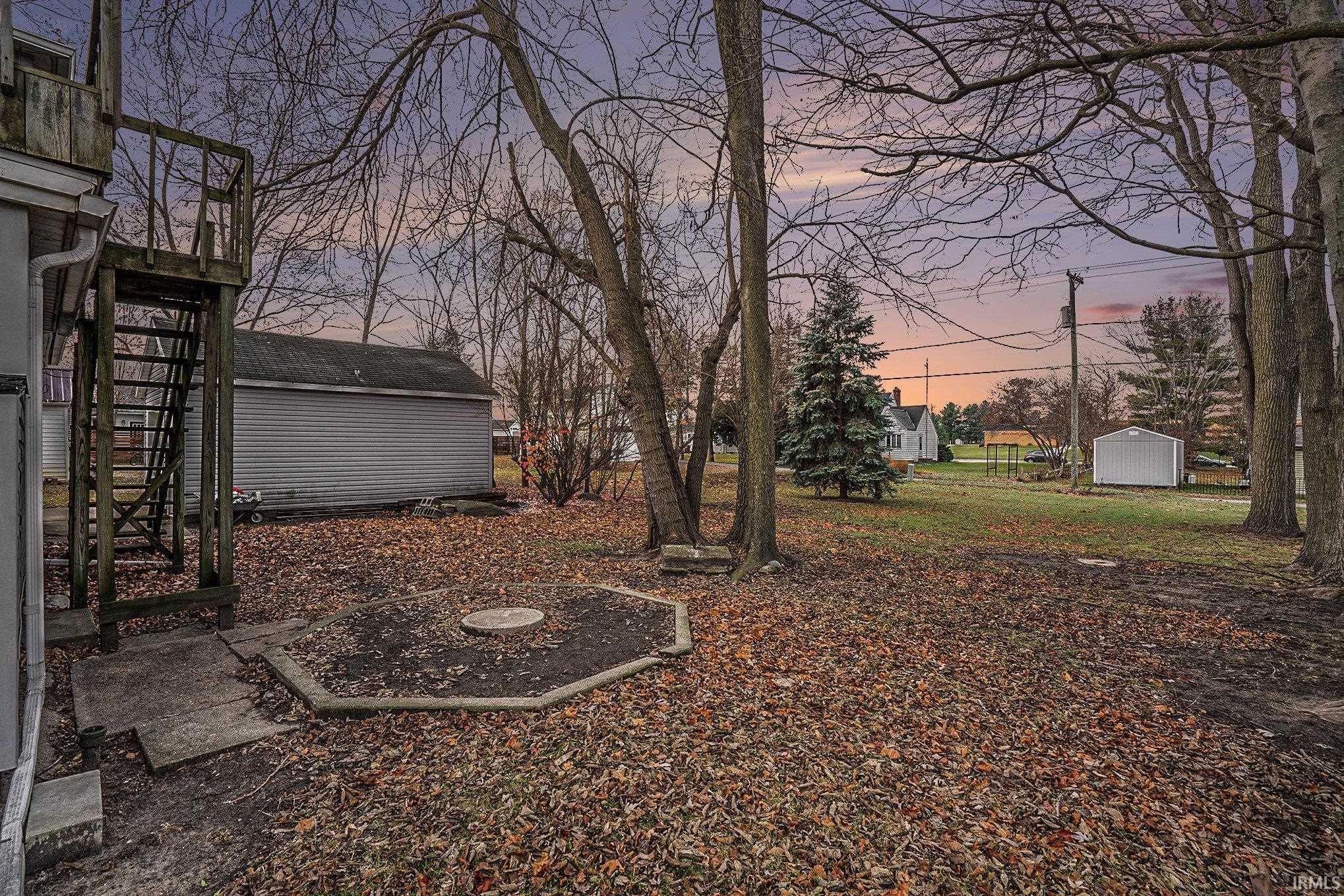 Yard at dusk featuring stairs and a shed