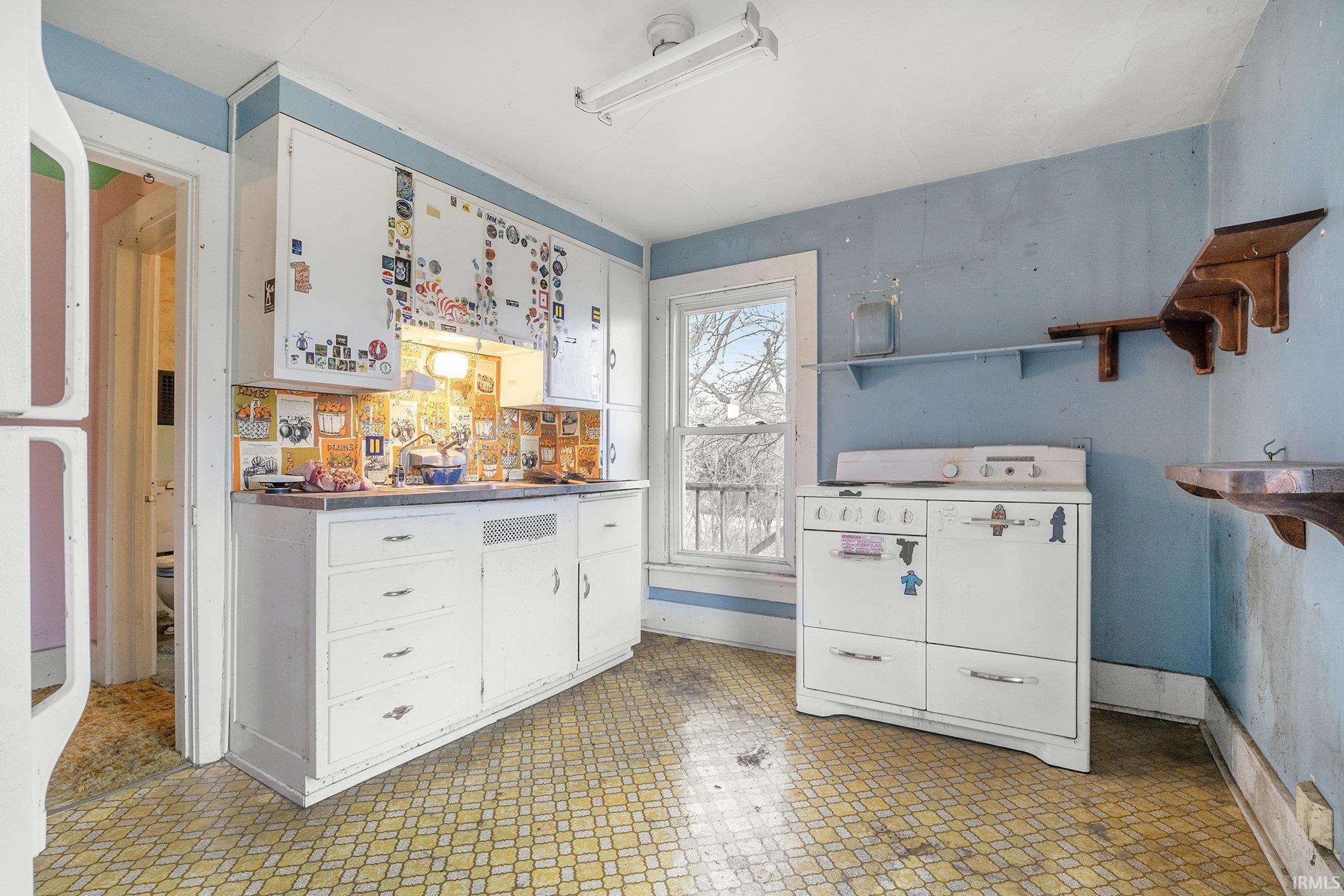Kitchen featuring white cabinets, light floors, white appliances, and open shelves