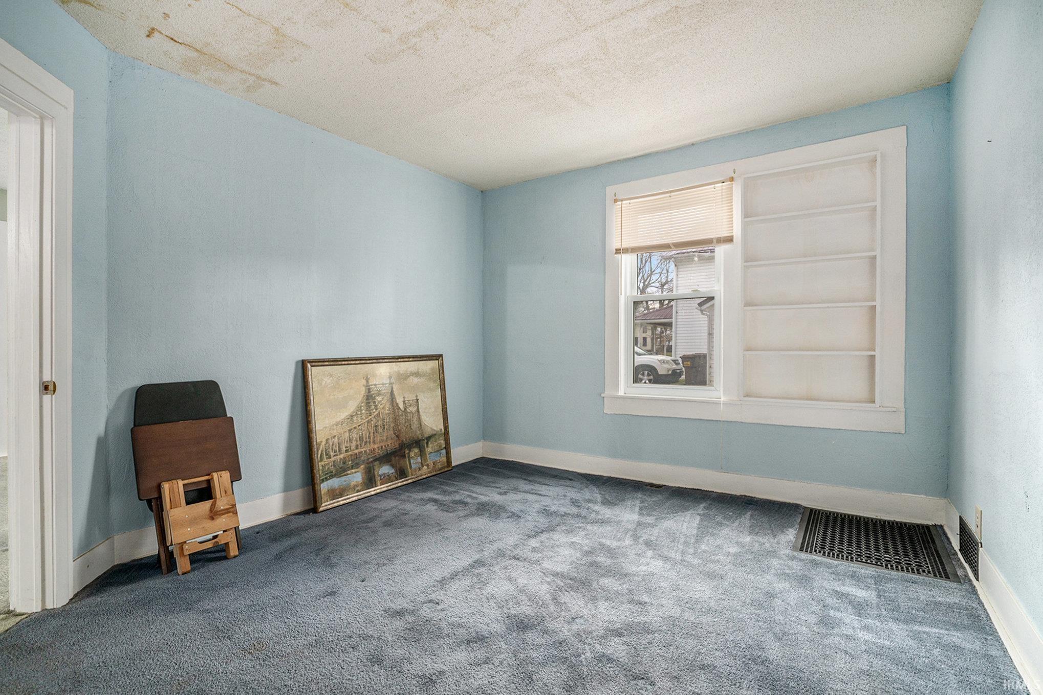 Empty room with a textured ceiling and carpet flooring