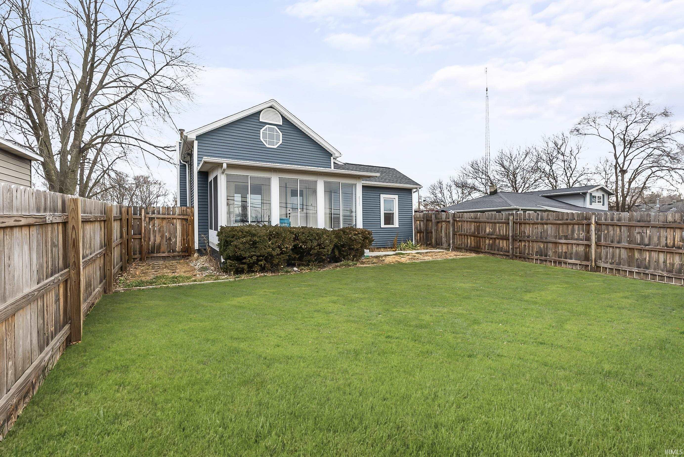 Back of house featuring a sunroom and a fenced backyard