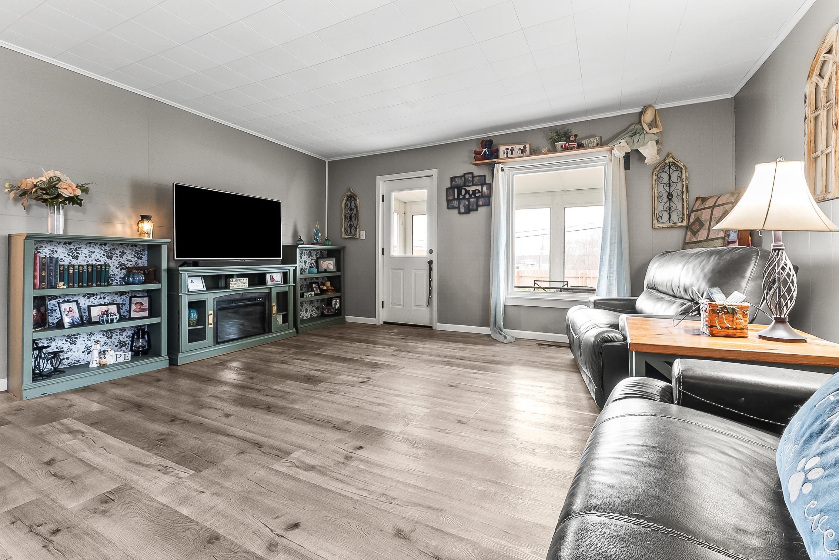 Living area featuring crown molding and wood finished floors