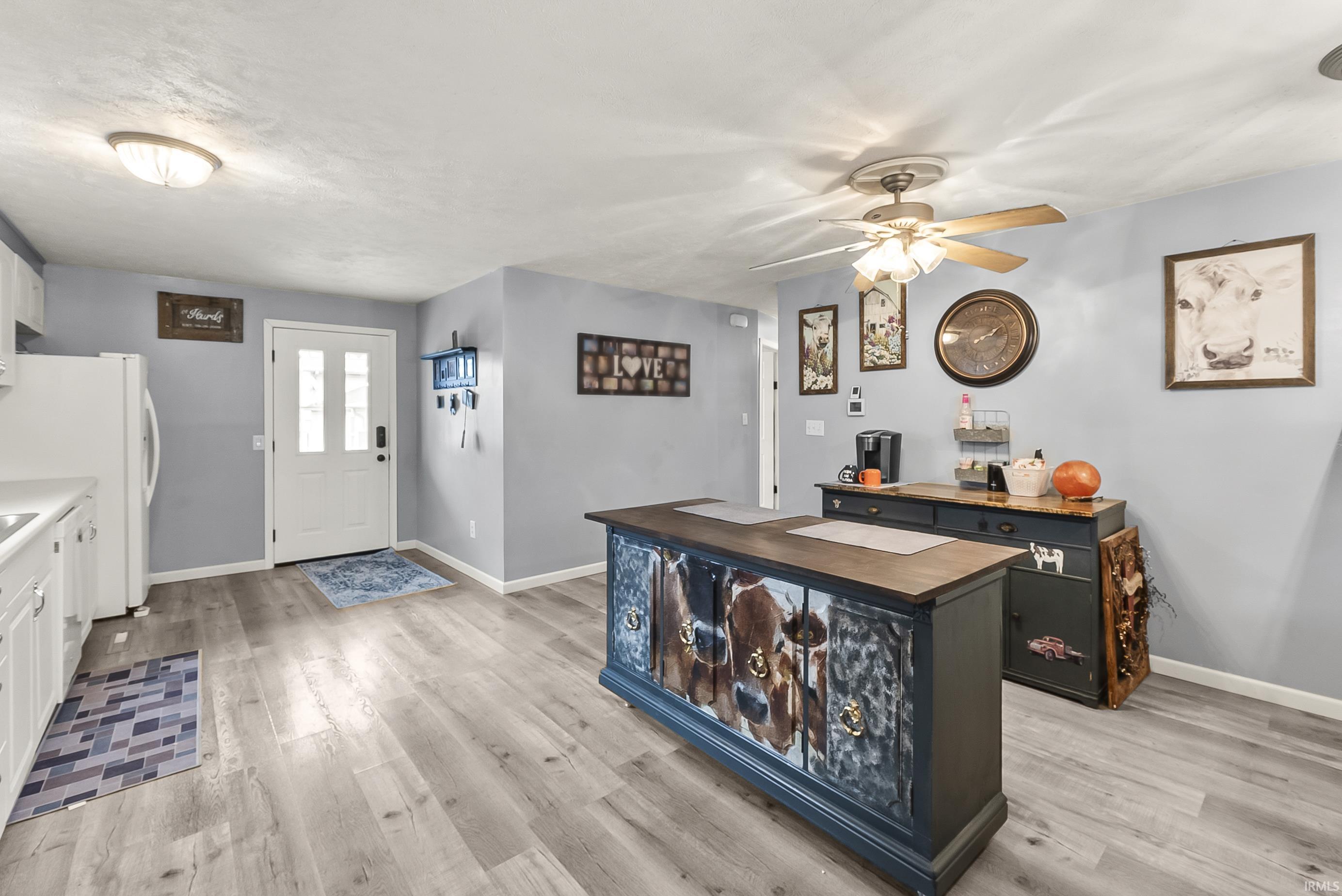 Entrance foyer with light wood finished floors and a ceiling fan