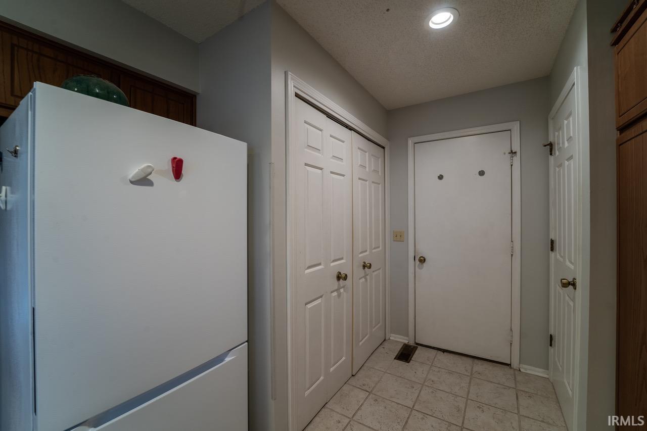 Entryway with a textured ceiling and tile patterned floors