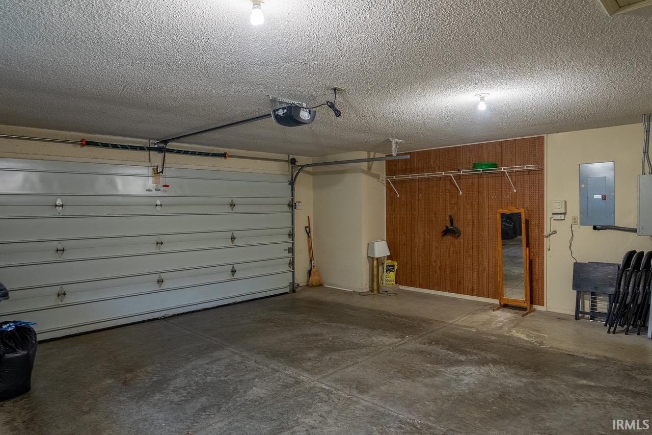 Garage featuring electric panel and a garage door opener