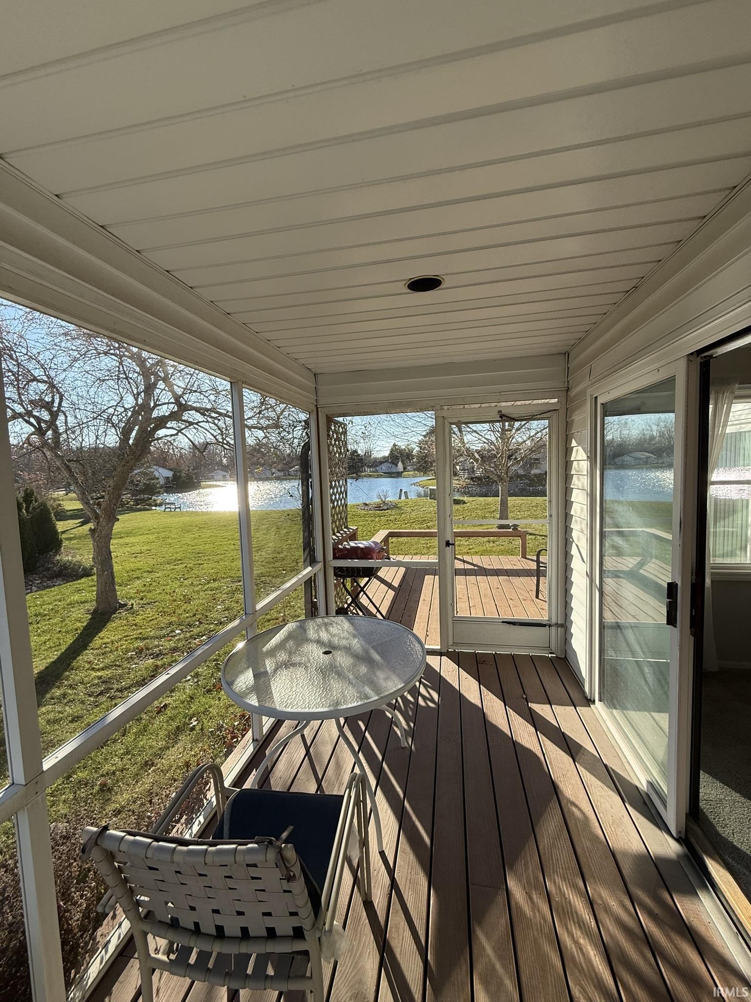 Unfurnished sunroom featuring a deck with water view
