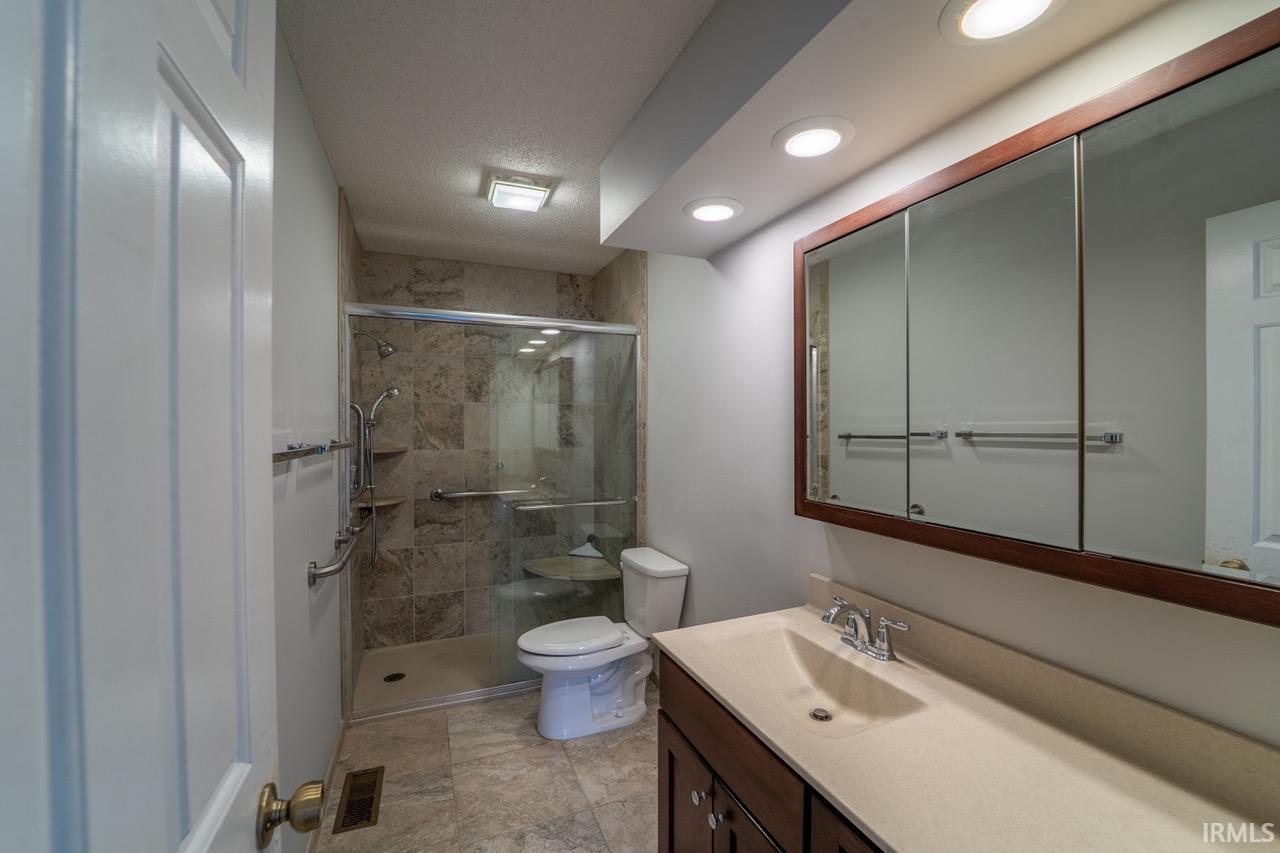 Full bathroom featuring vanity and a shower stall
