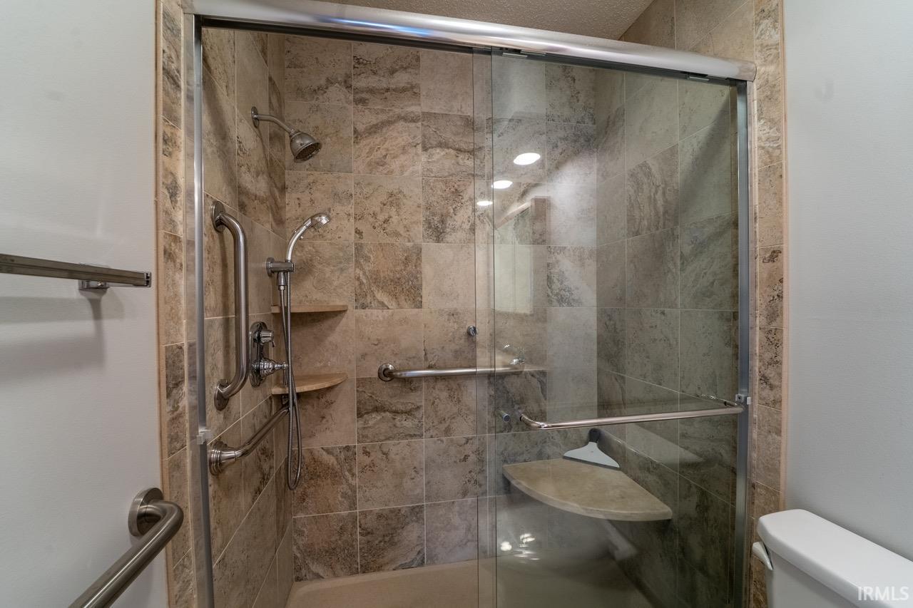 Bathroom featuring toilet and a shower stall