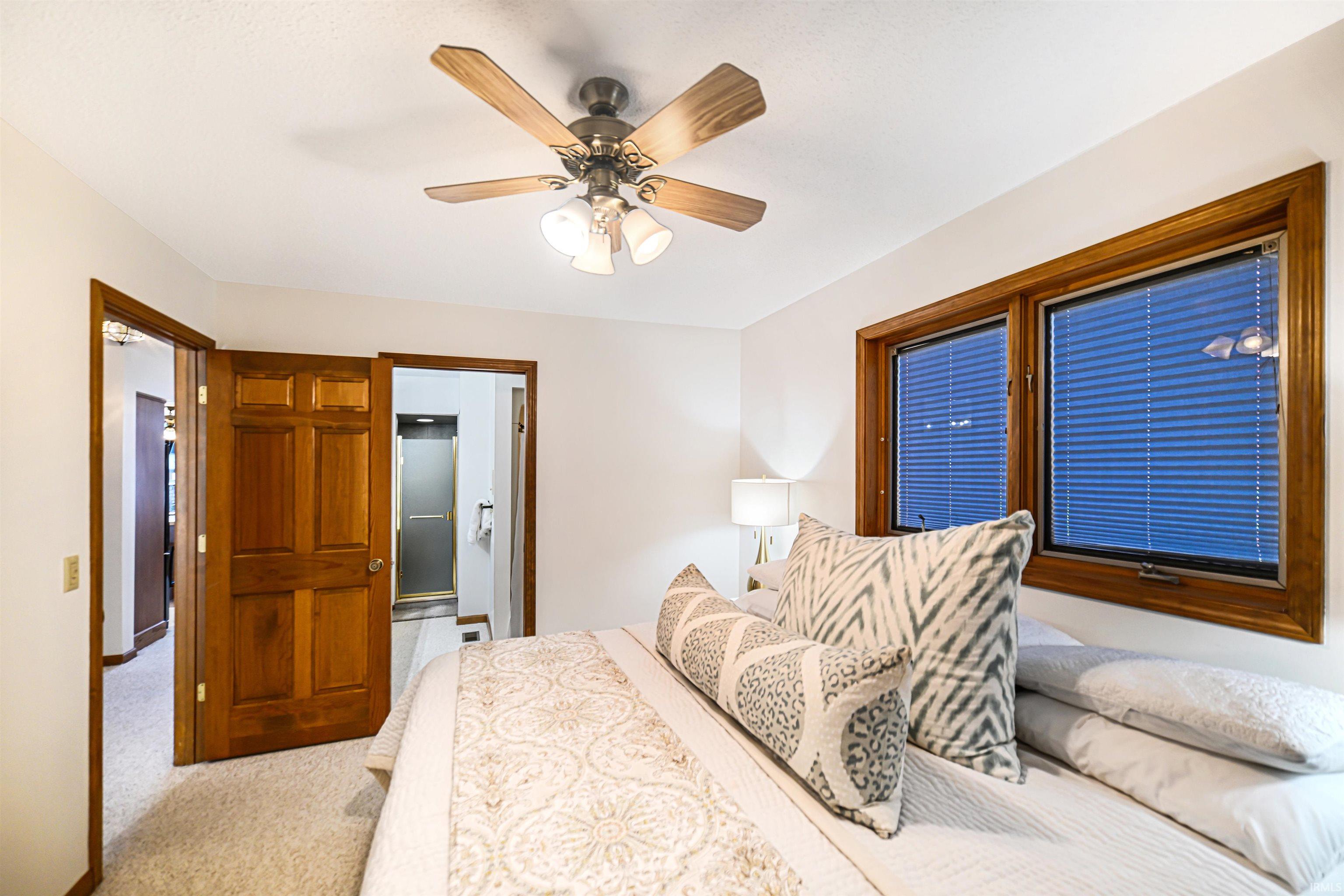 Bedroom featuring carpet floors, a ceiling fan, and ensuite bathroom