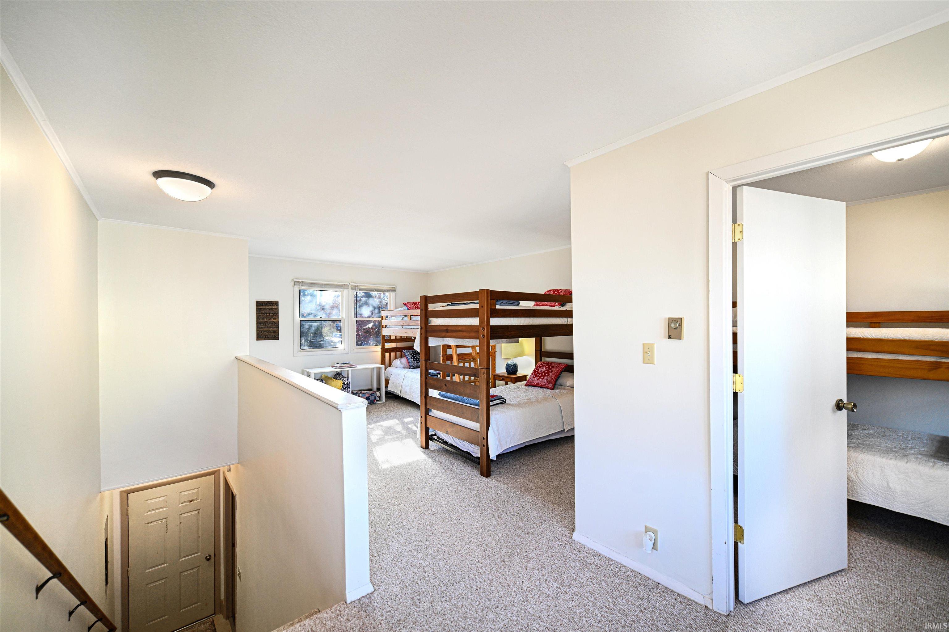 Bedroom featuring light colored carpet and ornamental molding