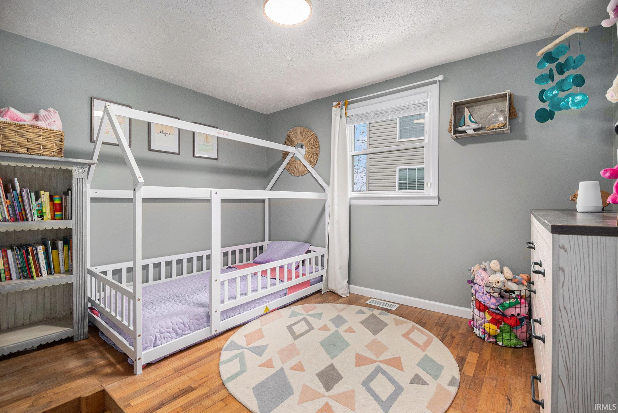 Bedroom featuring dark wood-type flooring and a textured ceiling