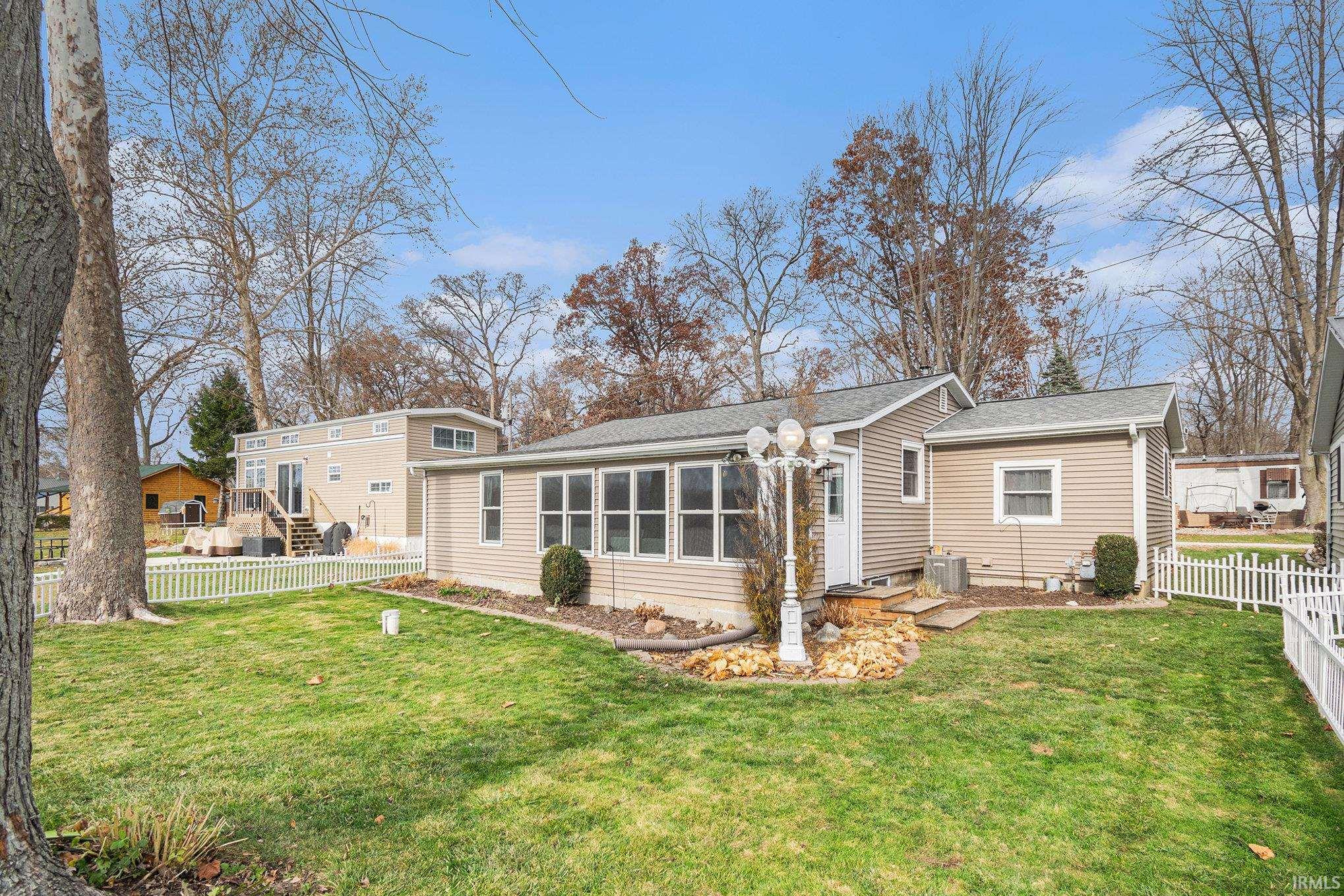 Rear view of house featuring roof with shingles and a sunroom