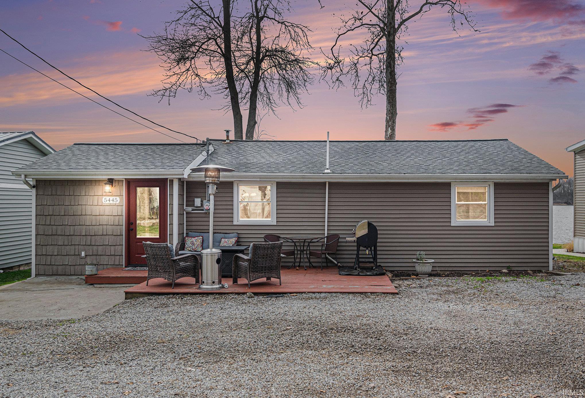 Rear view of property featuring roof with shingles and a wooden deck