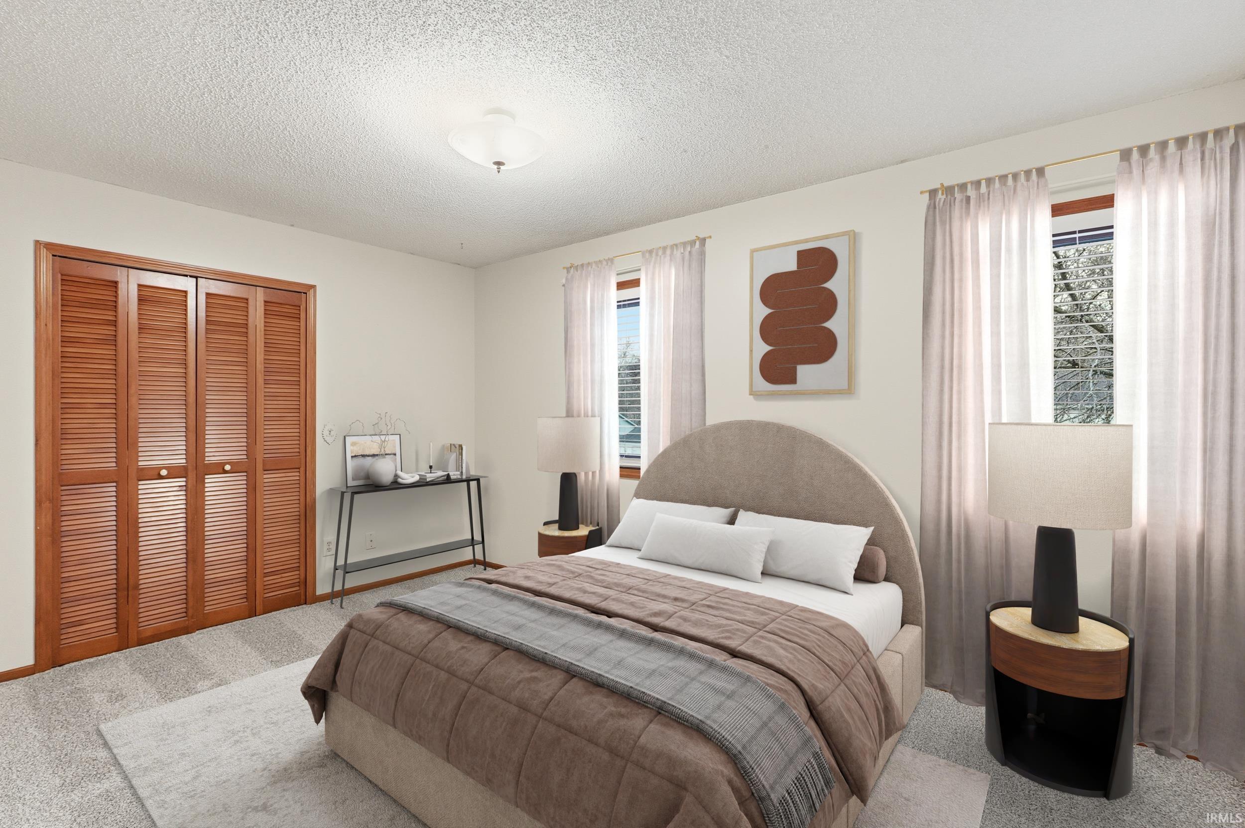 Bedroom with carpet flooring, a textured ceiling, and a closet