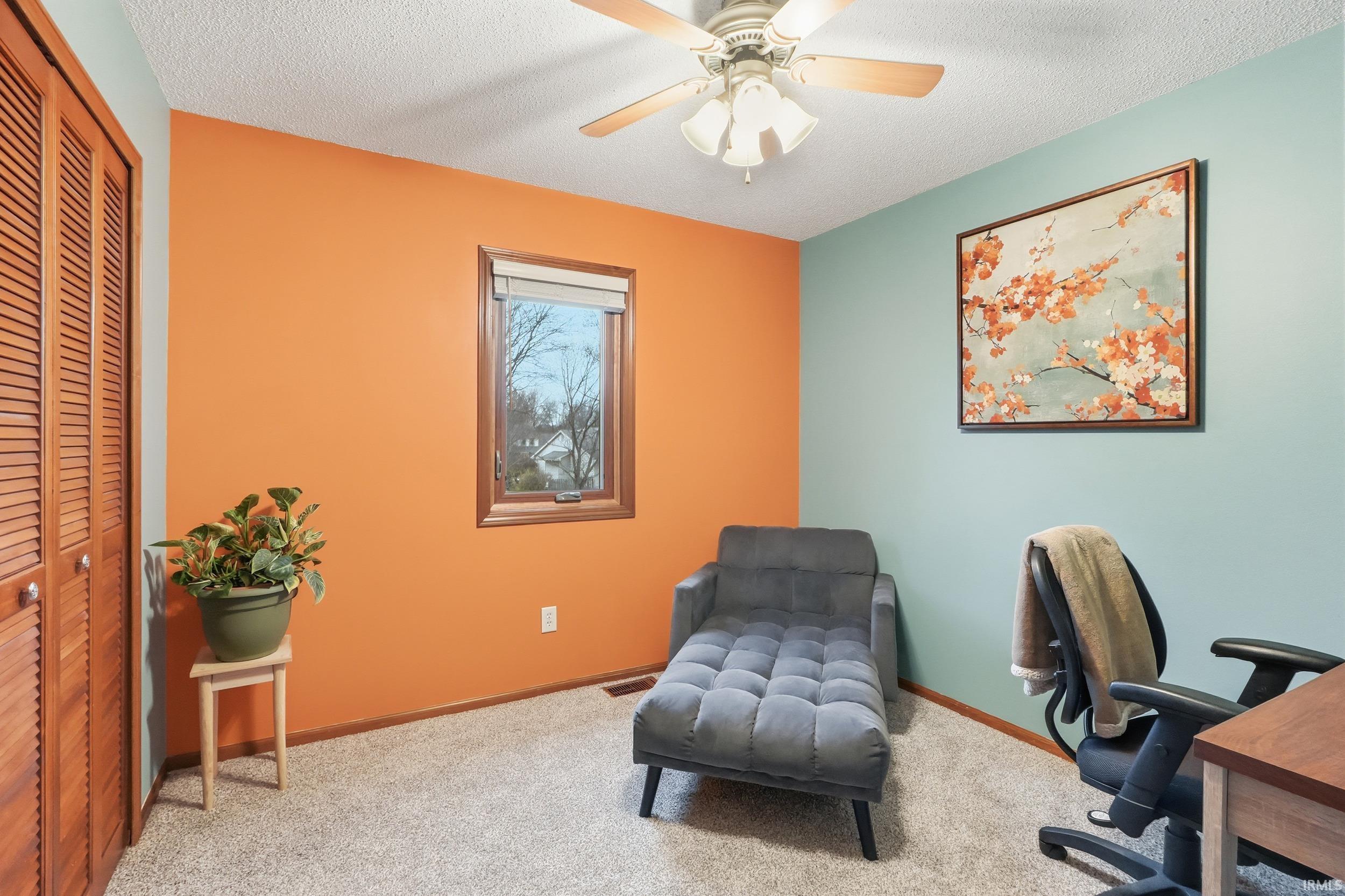 Carpeted office featuring a textured ceiling
