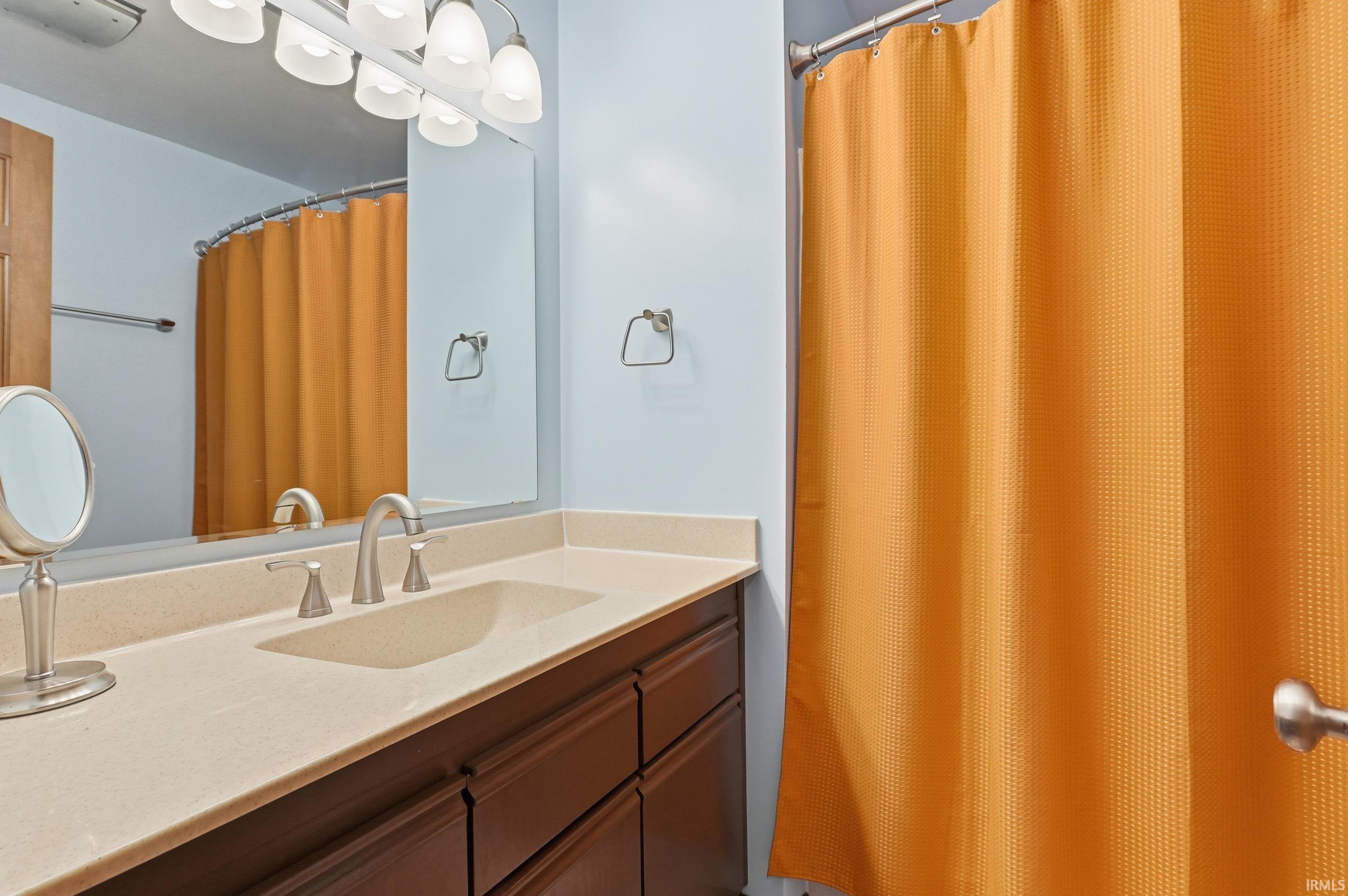 Full bath featuring vanity and curtained shower