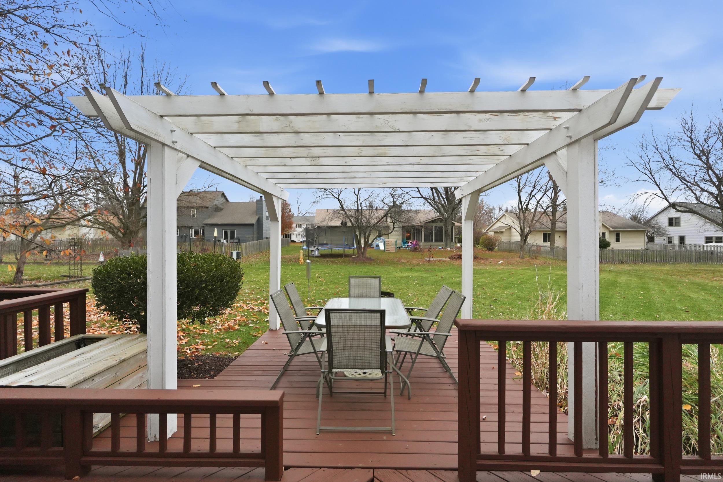 Deck with outdoor dining space, a residential view, and a trampoline