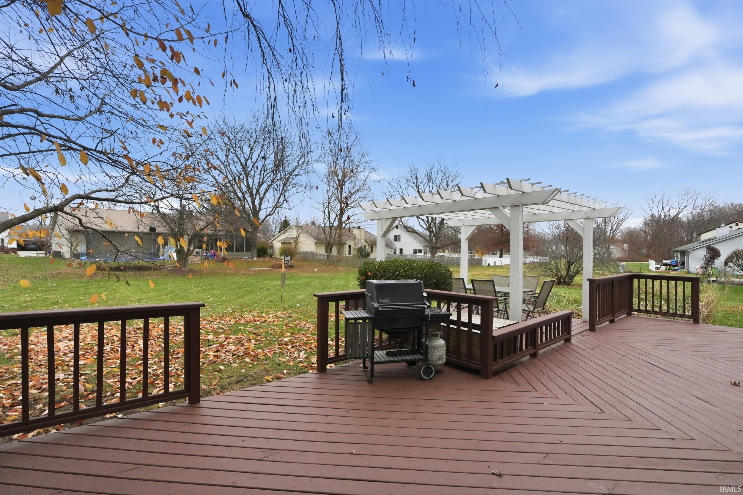 Wooden terrace featuring a residential view, a yard, and area for grilling