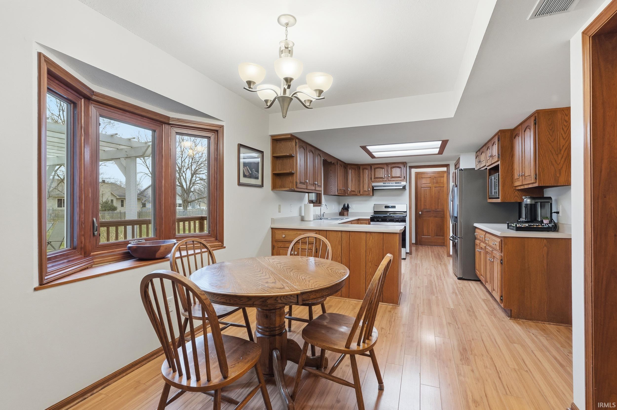 Dining room featuring light wood finished floors and a chandelier