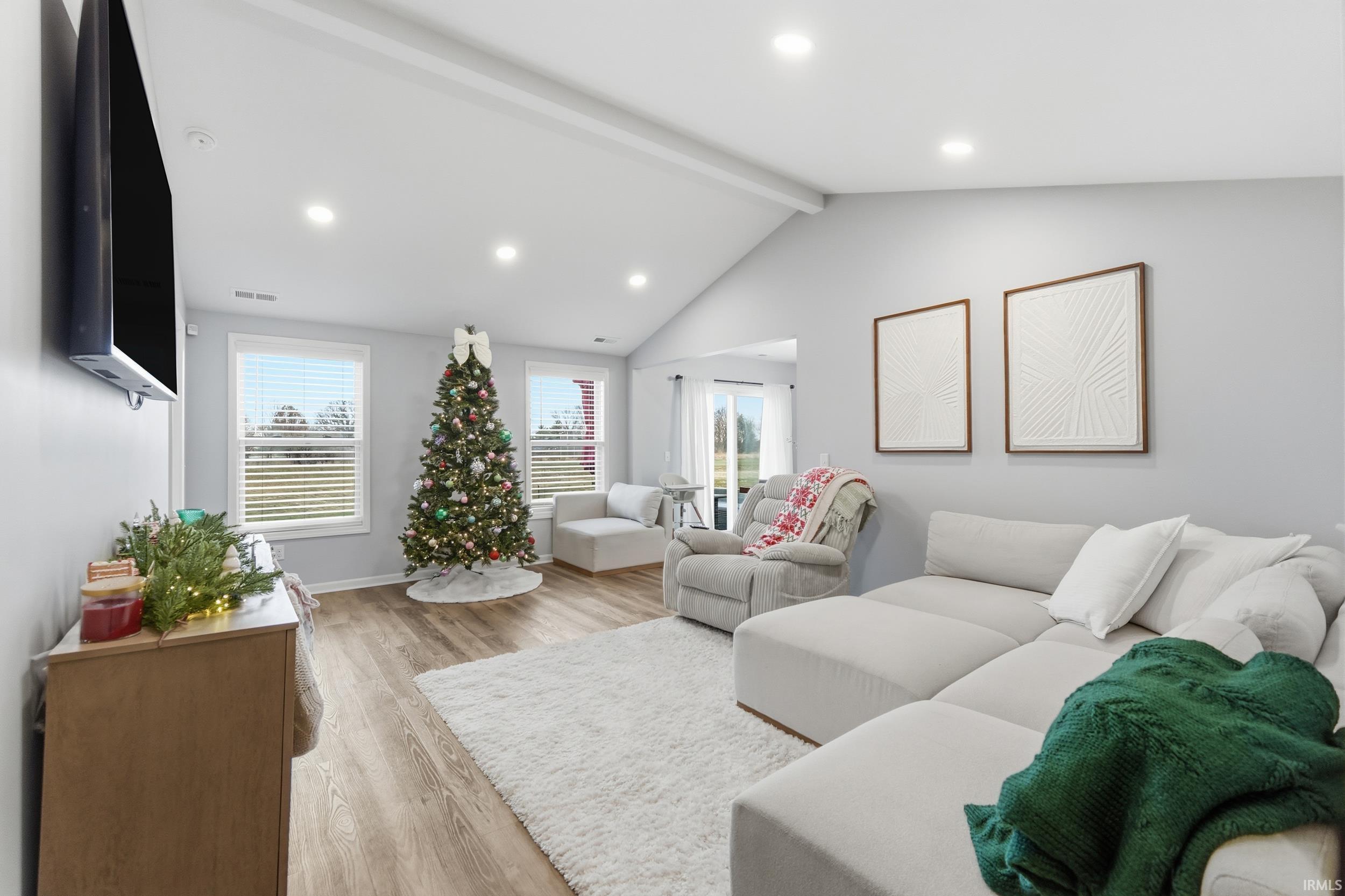 Living area with light wood-style floors and recessed lighting