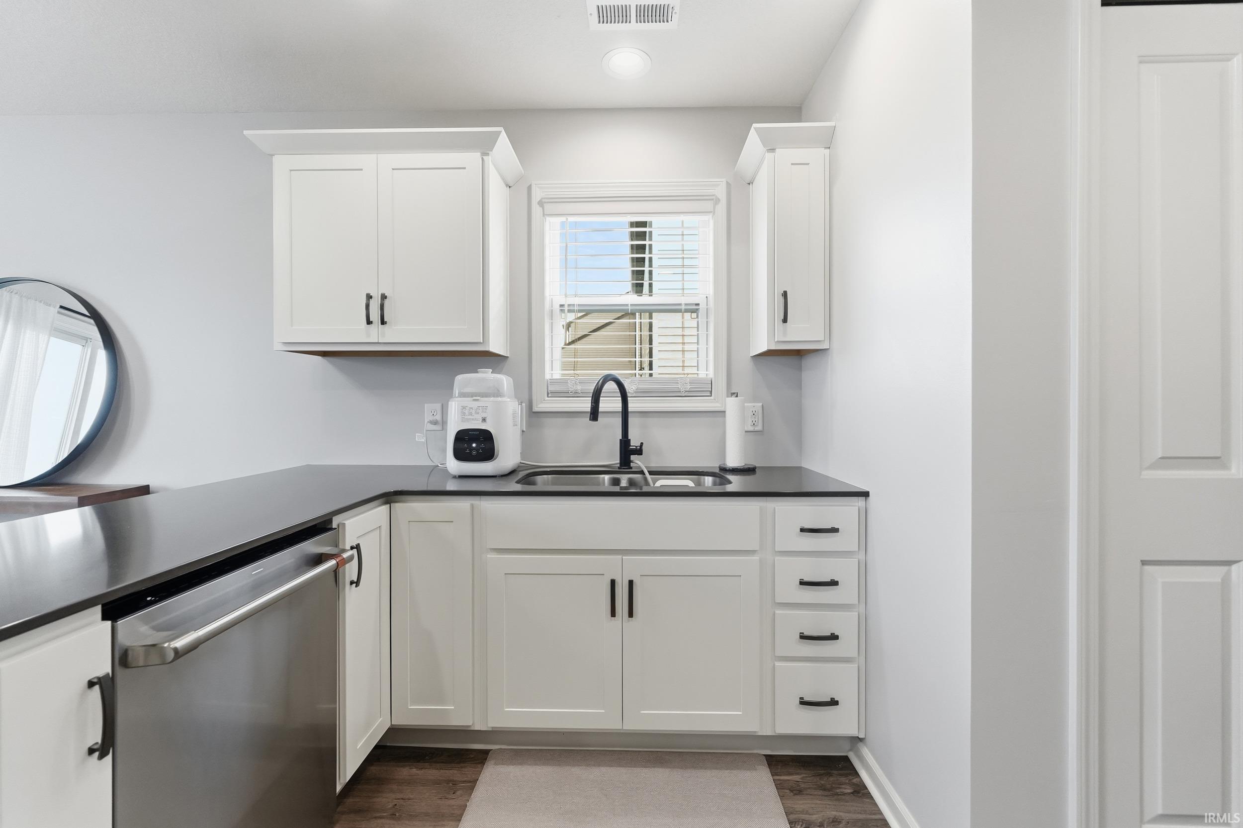 Kitchen featuring dishwasher, white cabinetry, dark wood-style floors, and recessed lighting