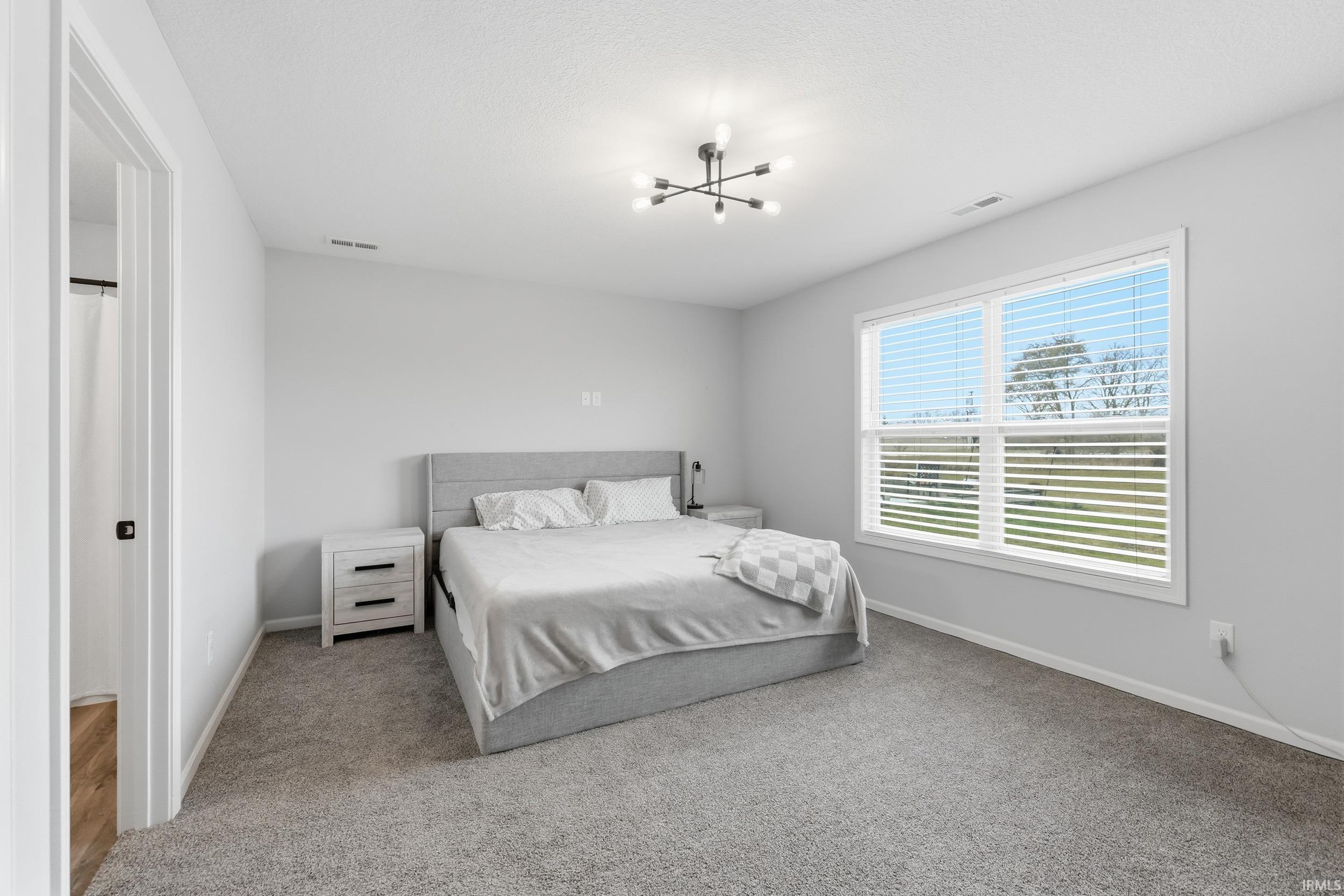 Bedroom with carpet flooring and a chandelier
