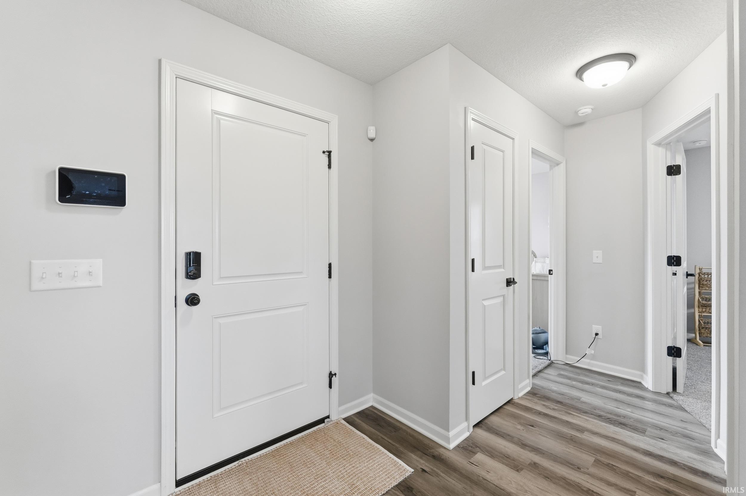 Foyer featuring a textured ceiling and wood finished floors