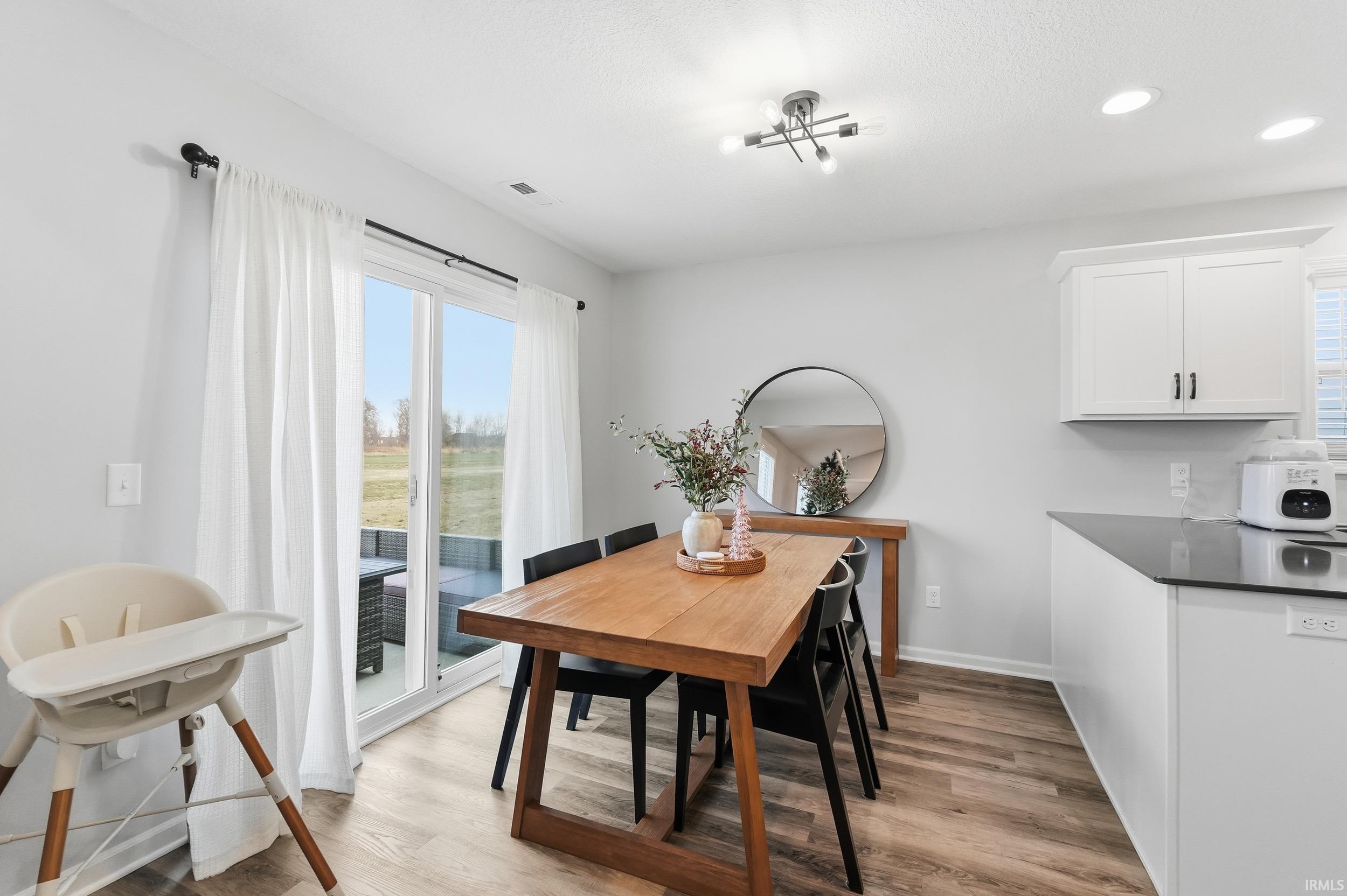 Dining space with light wood-style floors and recessed lighting
