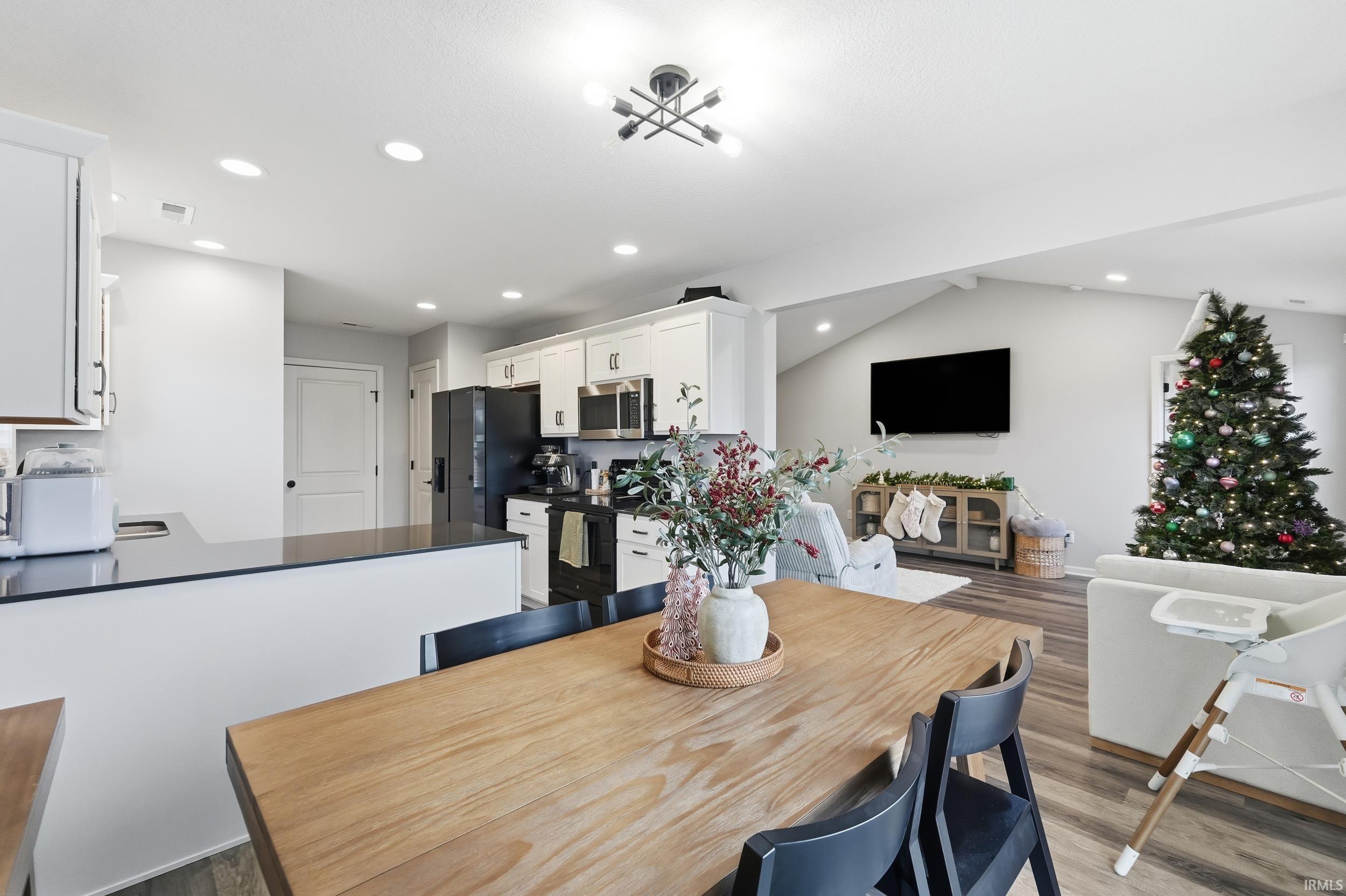 Dining area featuring vaulted ceiling, light wood-type flooring, and recessed lighting