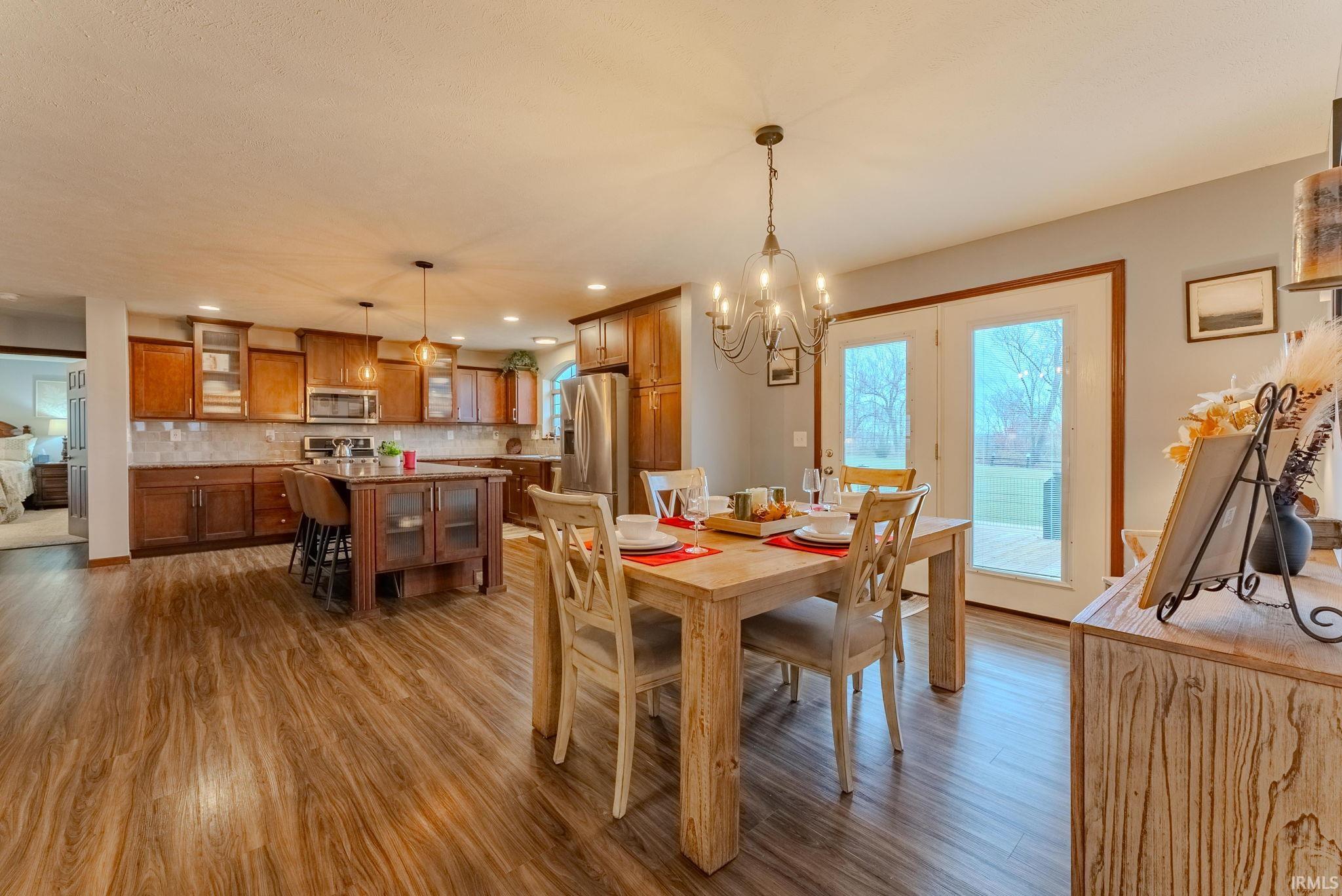 Dining room featuring dark wood finished floors, a chandelier, and recessed lighting