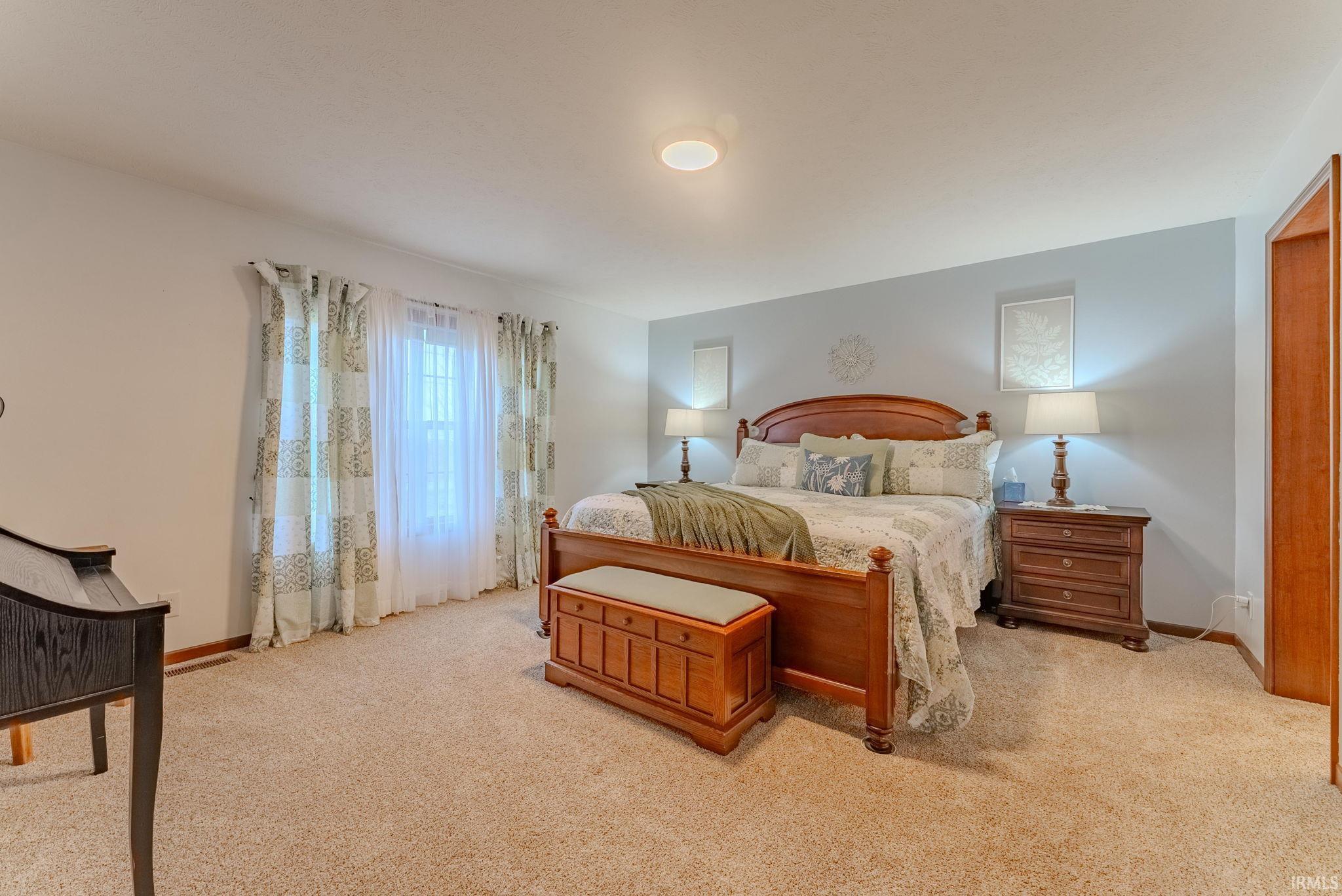 Bedroom featuring light carpet