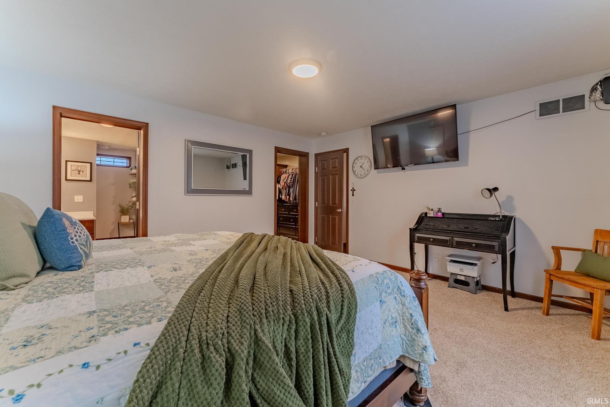 Carpeted bedroom featuring a spacious closet and connected bathroom