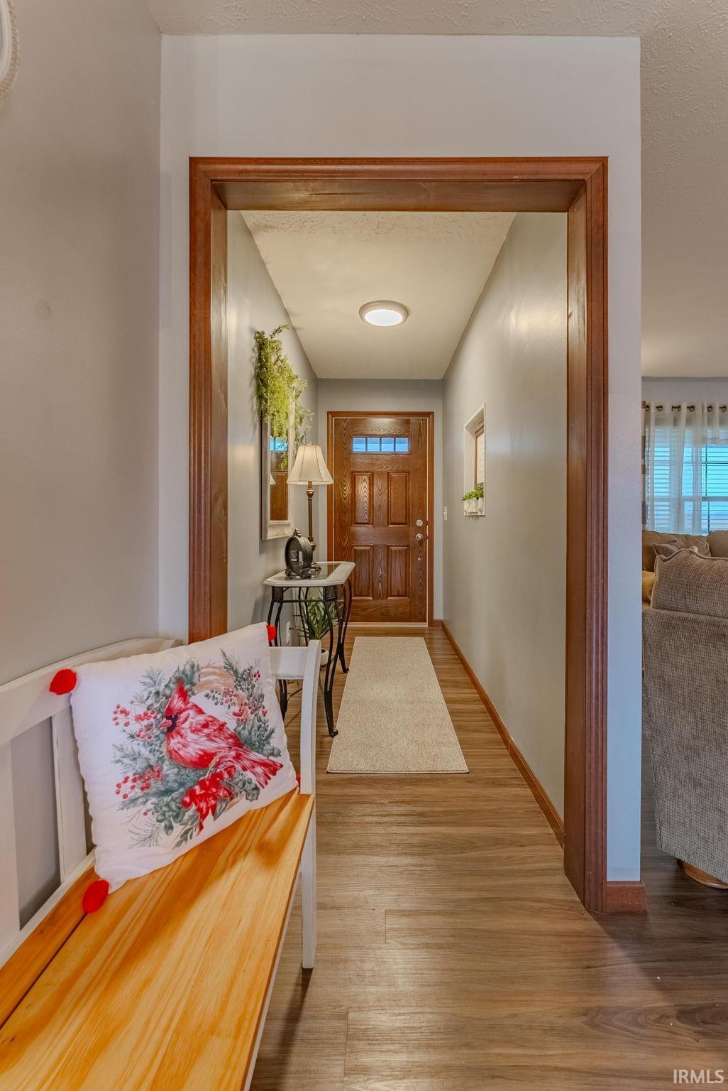 Hall with light wood-style flooring and baseboards