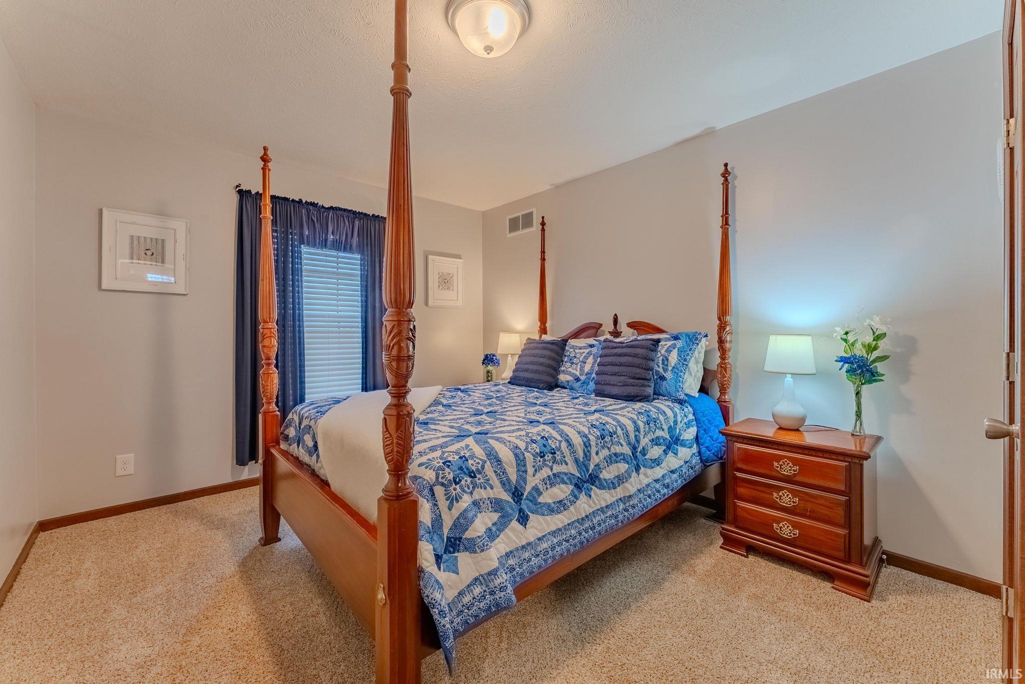 Bedroom with baseboards and light carpet