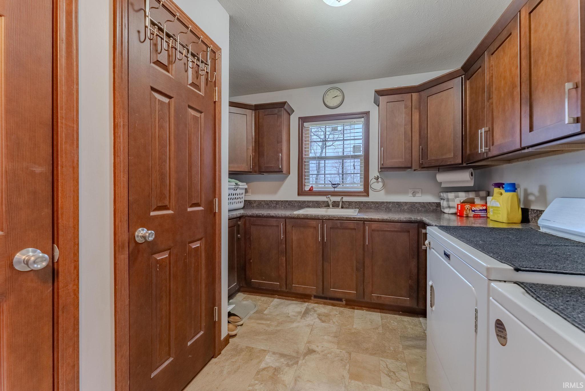 Kitchen with dark countertops and washing machine and dryer