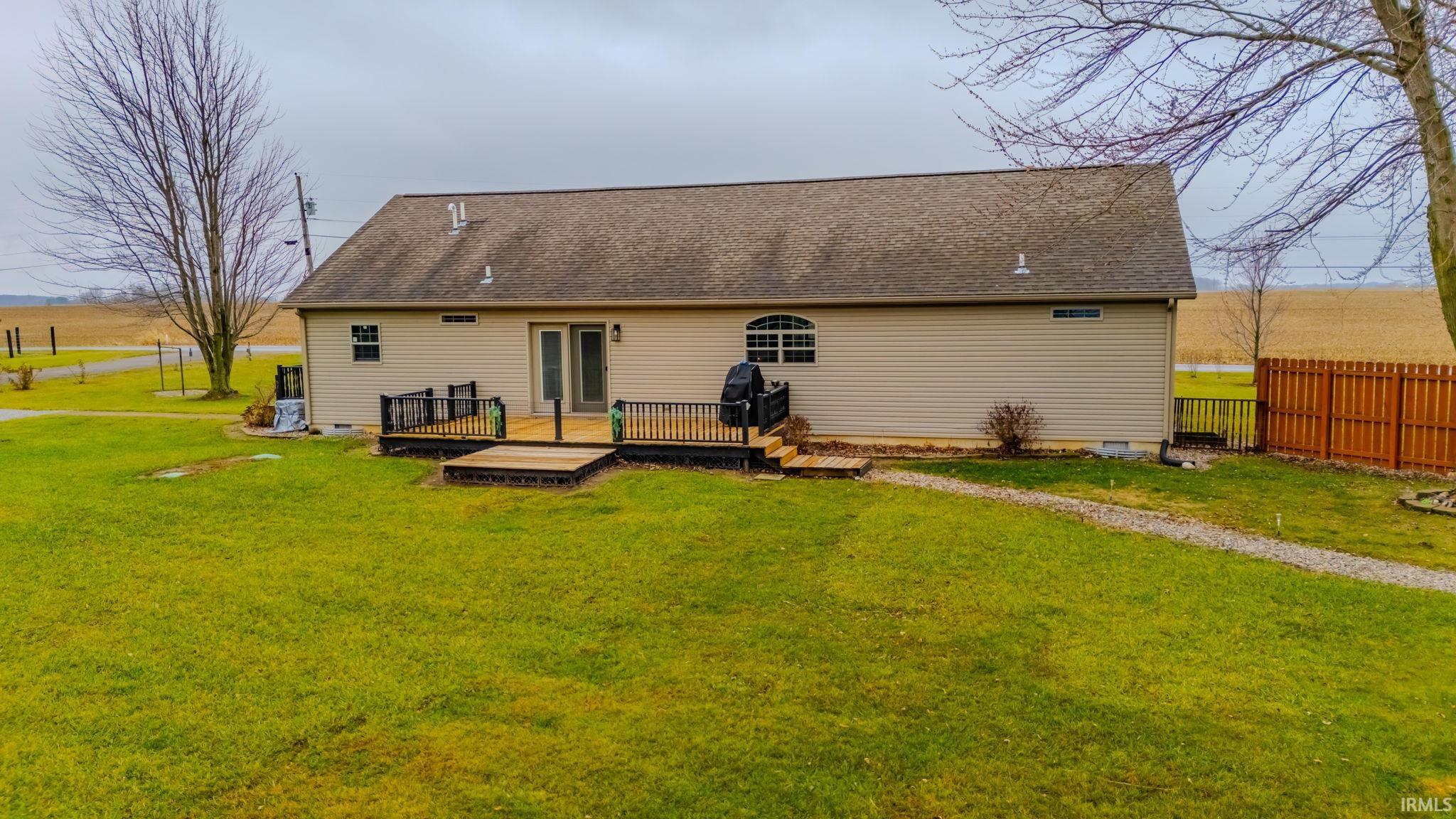 Rear view of house with a deck, crawl space, and roof with shingles
